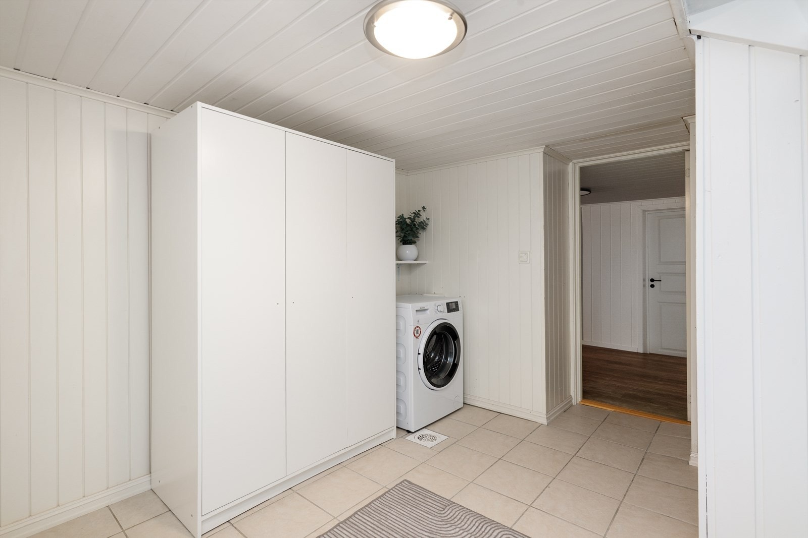 Vaskerommet har flis på gulv og panel på vegg. Galleribilde