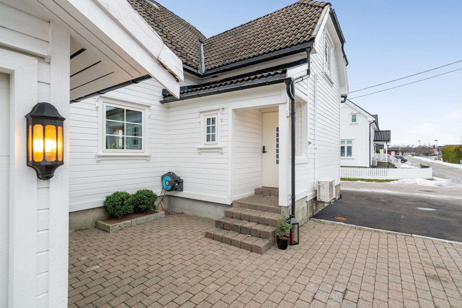 Boligen har et flott, overbygget inngangsparti og lunt, hellelagt gårdsrom hvor det er inngang til garasjen via sidedør. Galleribilde