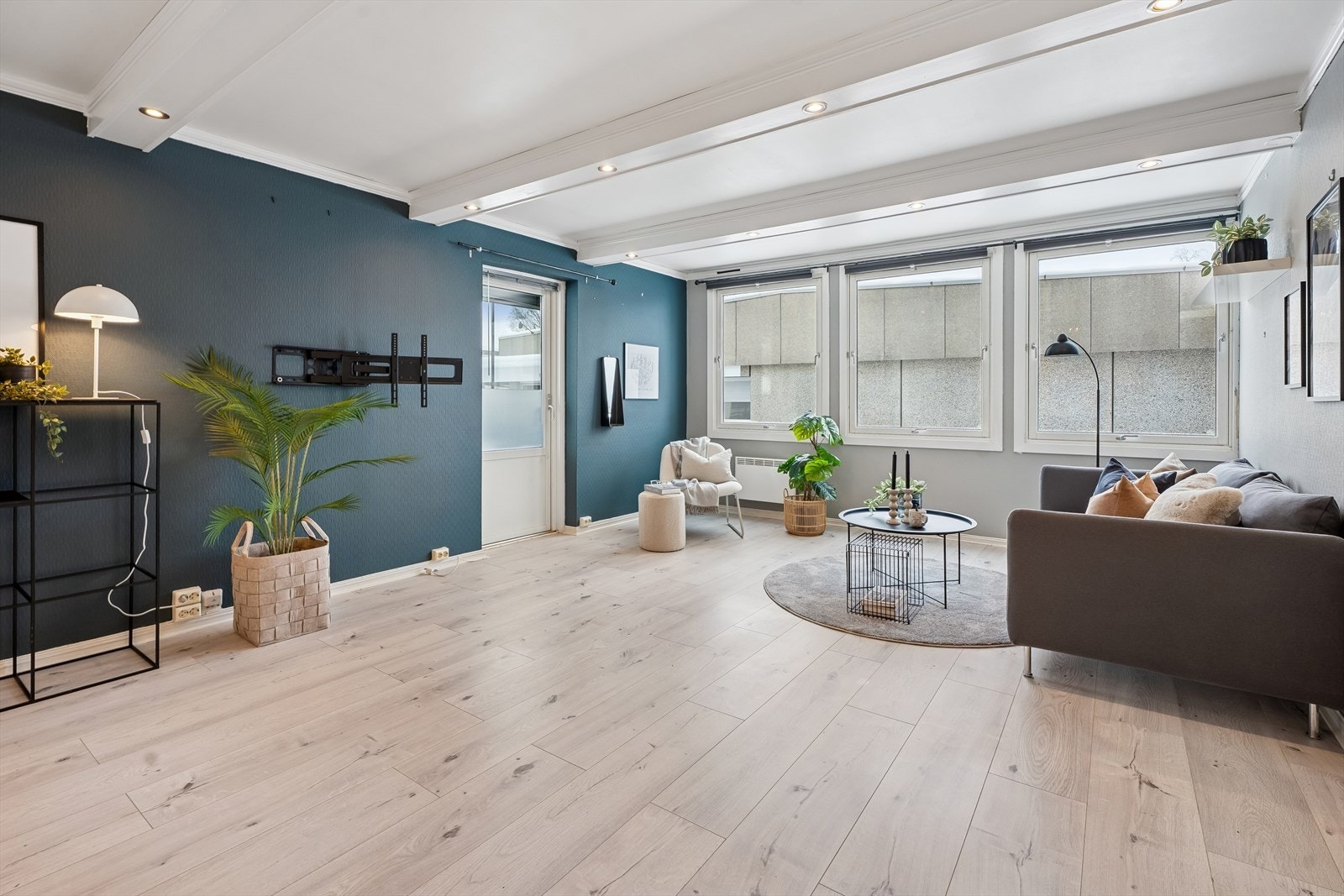 En mørk fondvegg skaper en stilfull kontrast og dybde i stuen. Galleribilde