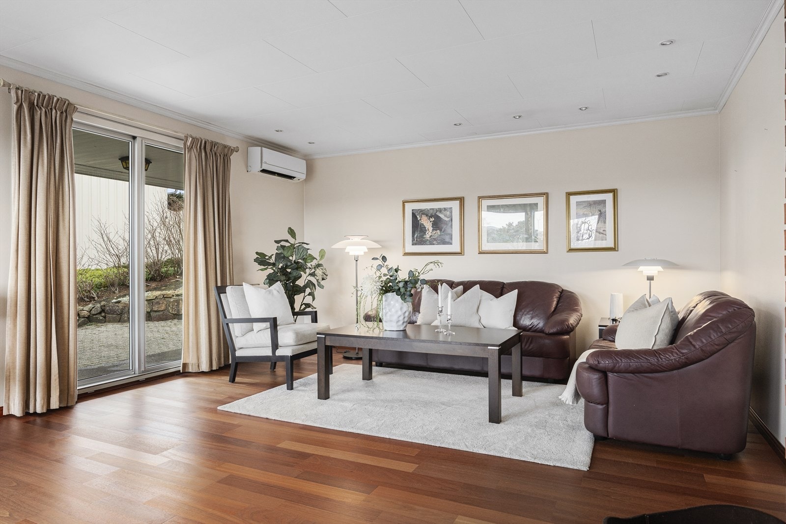 Stuen er romslig og innbydende, med store vindusflater som slipper inn rikelig naturlig lys og gir utsikt mot uteområdet. Galleribilde