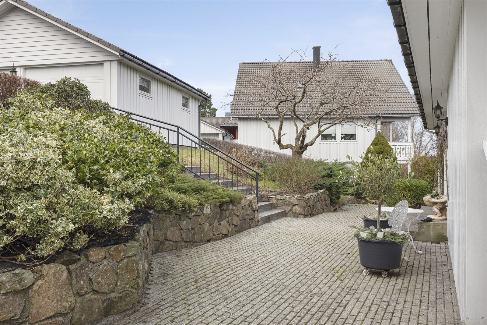 Belegningsstein ved inngangspartiet og et asfaltert gårdsrom gjør eiendommen både funksjonell og presentabel. Solide murer gir et godt visuelt inntrykk og skaper en lun atmosfære. Galleribilde