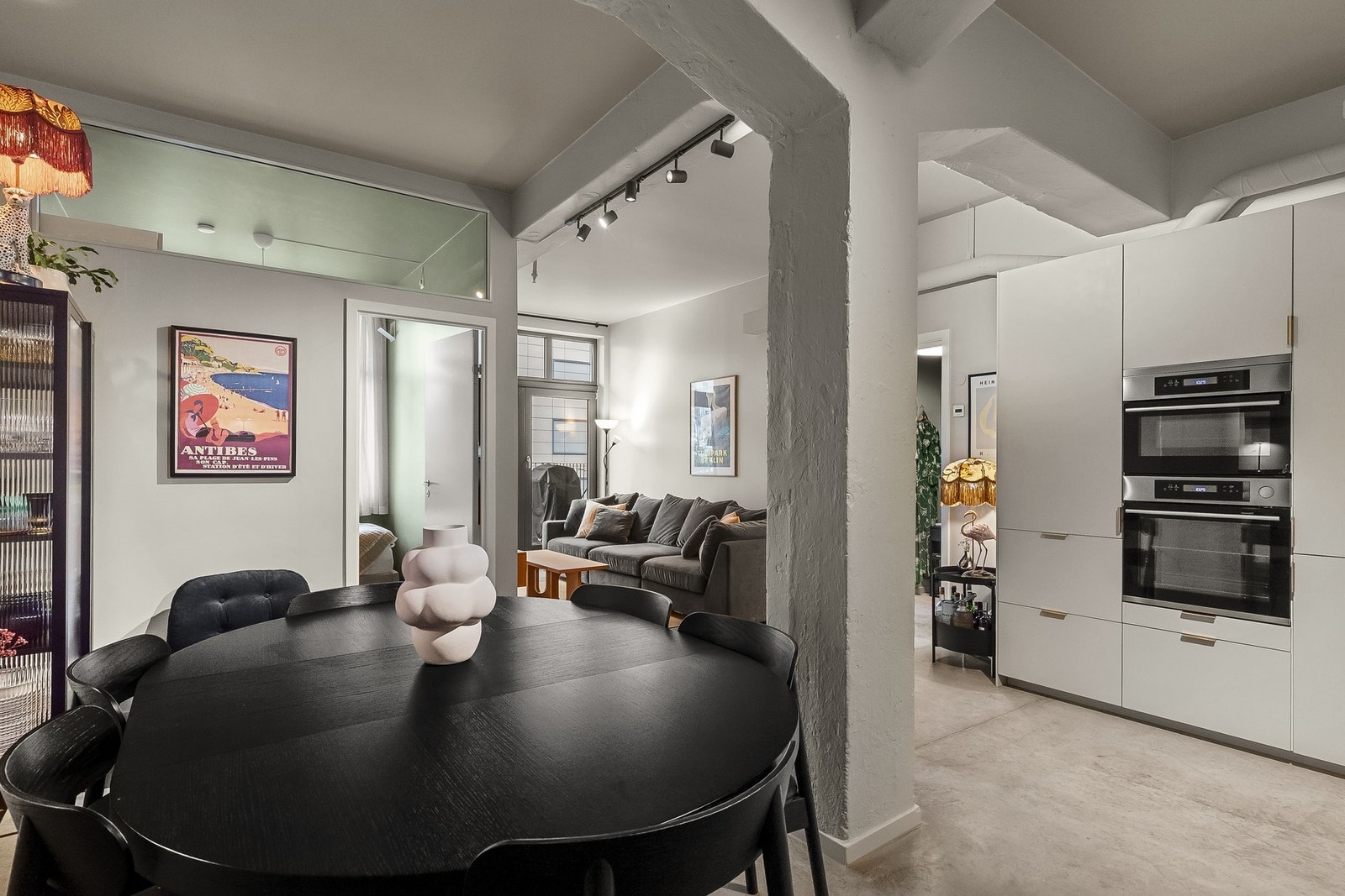 Karakteristiske betongsøyler gir hint til byggets opprinnelse og fungerer som en naturlig romdeler. Galleribilde