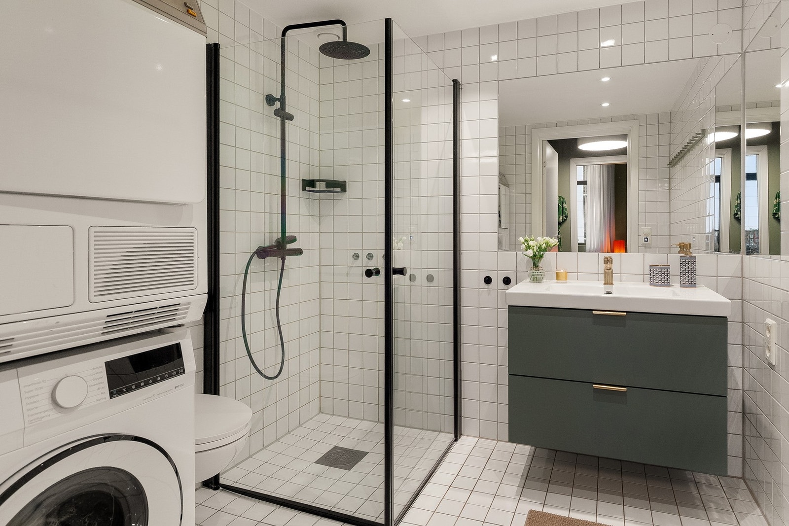 Flislagt bad med vaskesøyle i en lys og tidsnøytral utførelse. Servantinnredning fra 2022. Galleribilde