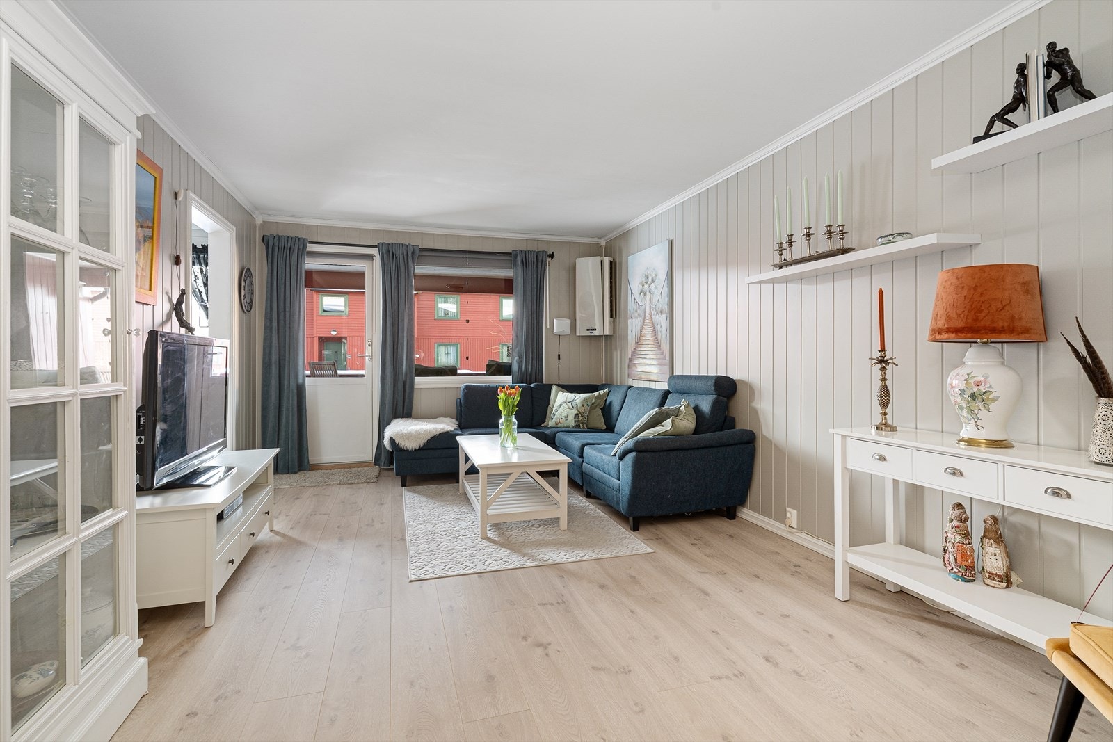 Fin og romslig stue med stor vindusflate og utgang til lun, overbygget balkong mot vest. Leiligheten er pusset opp med nytt laminatgulv i 2025. Galleribilde