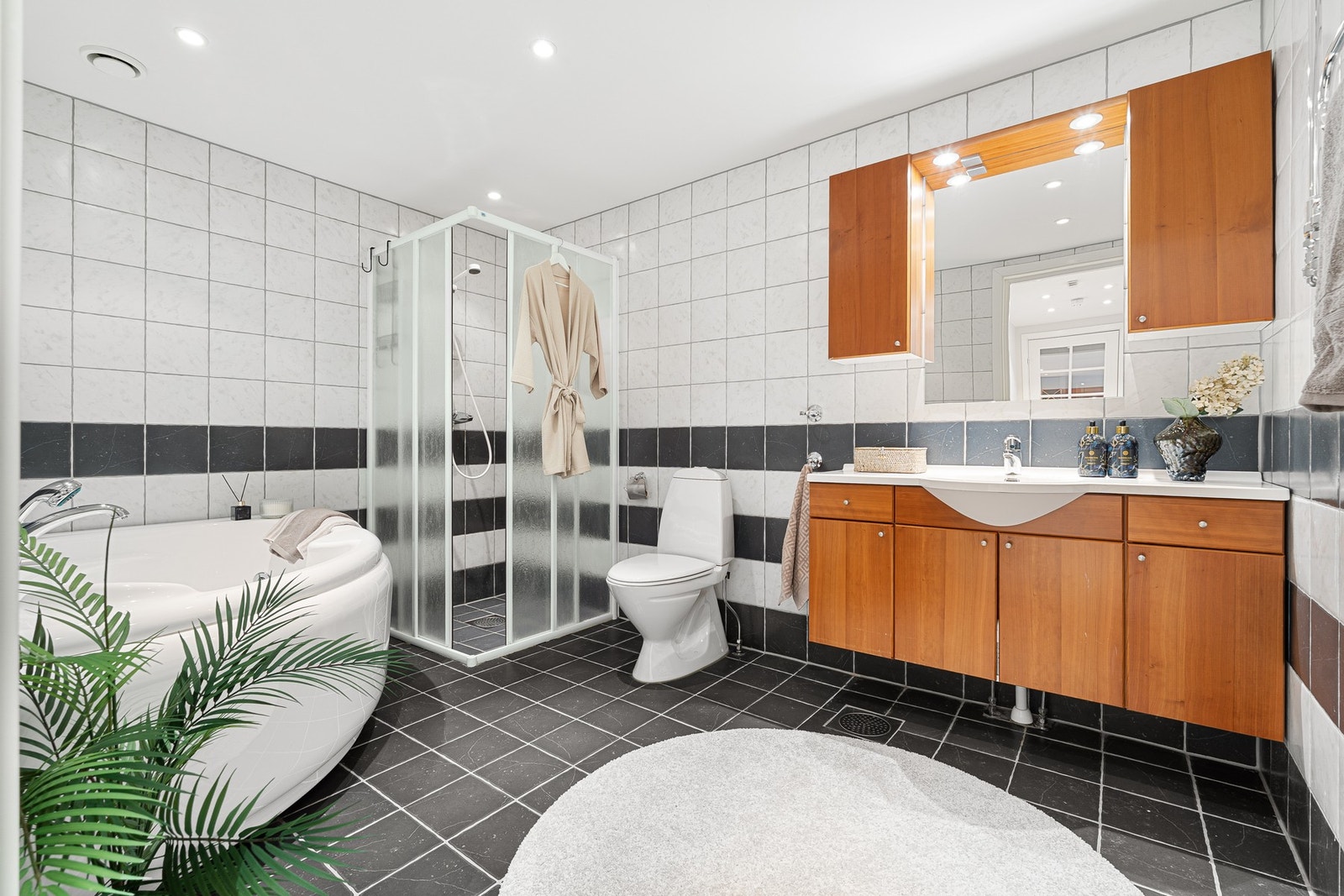 Stort baderom med flislagte overflater og fin innredning. Galleribilde