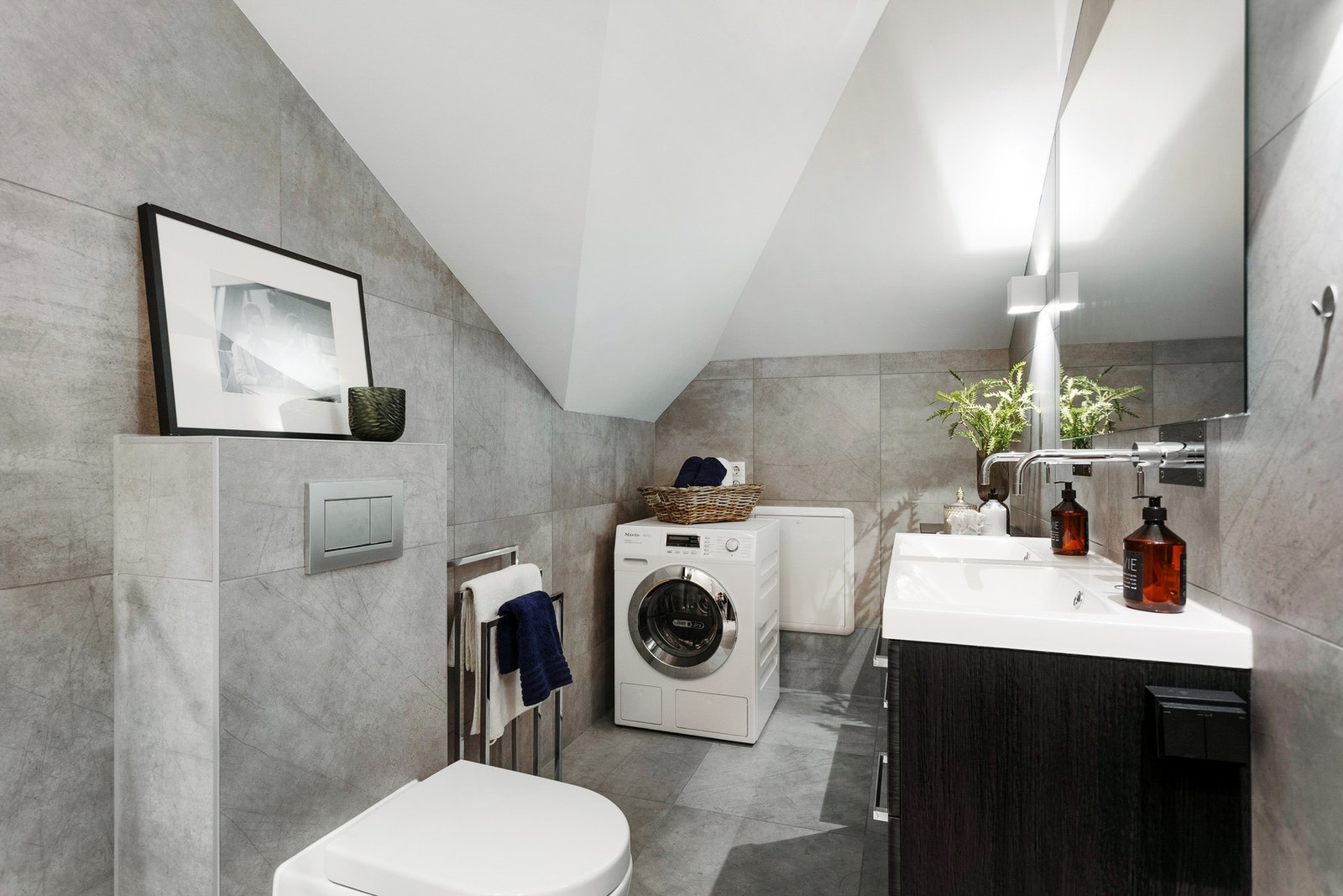 Badet fremstår delikat og moderne. Her er det varme i gulvet og opplegg for vaskemaskin. Galleribilde