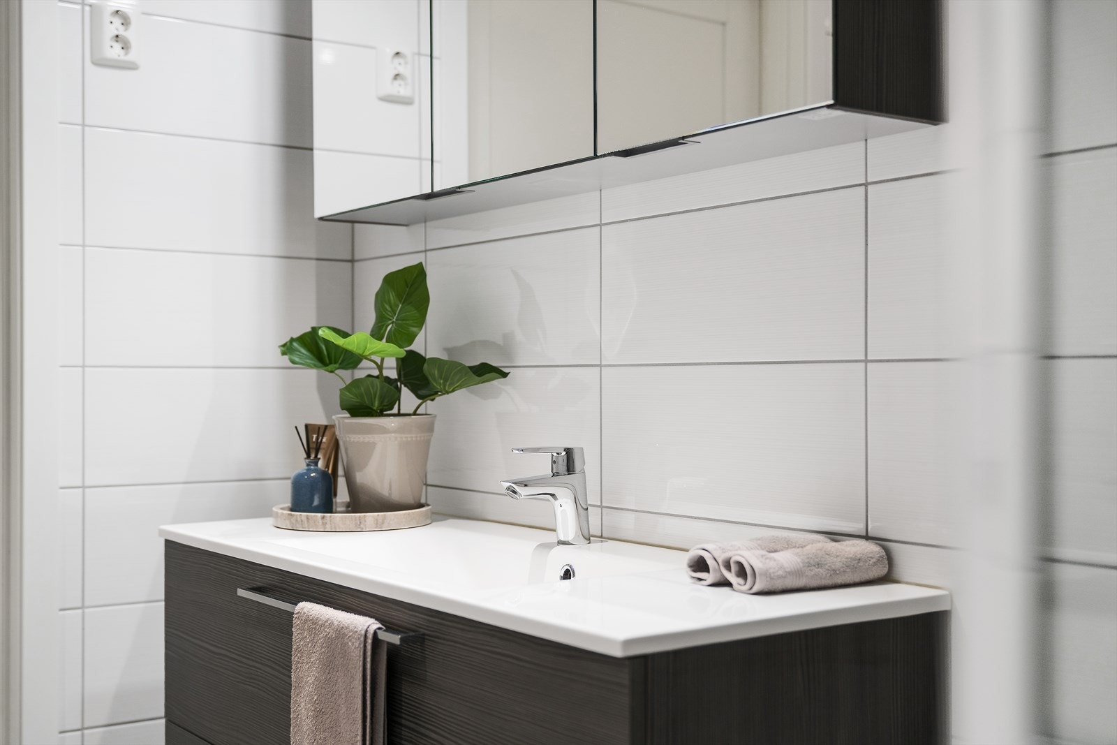 Badet inneholder dusjhjørne med innfellbare glassvegger, vegghengt wc og baderomsinnredning. Galleribilde