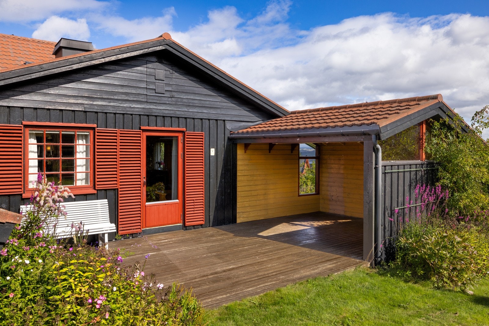 Fra stuen er det utgang til delvis overbygget terrasse med fin ettermiddags-/kveldssol - perfekt for lange sommerkvelder Galleribilde