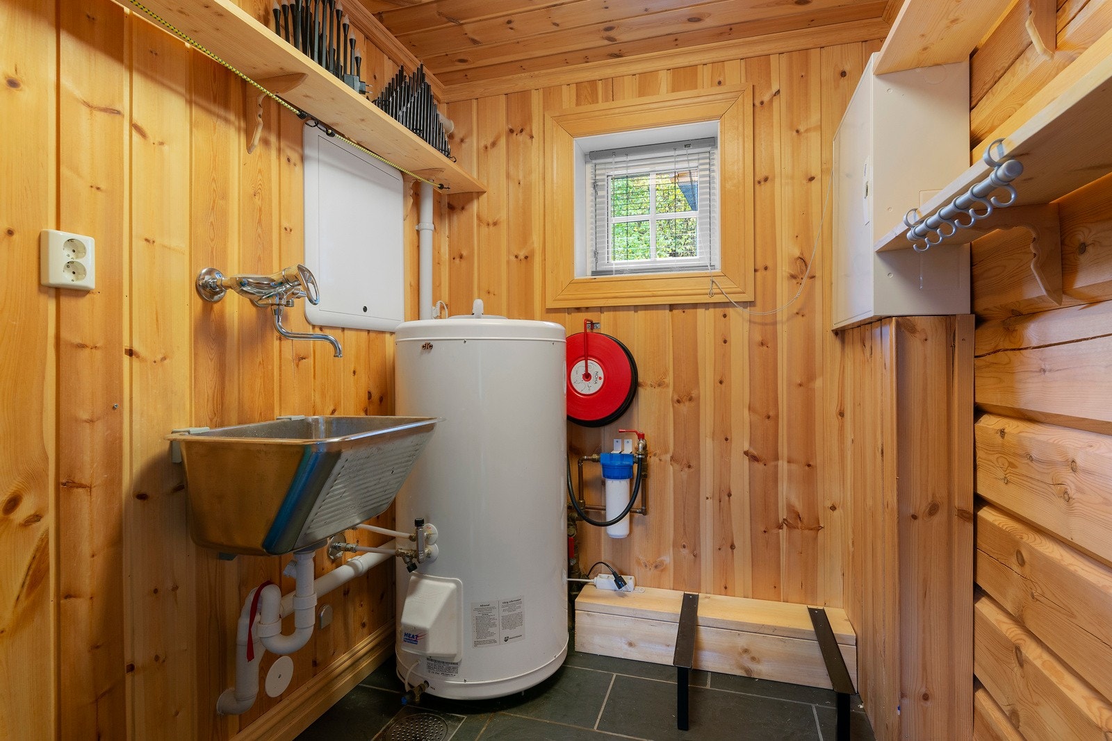 Vaskerom med opplegg for vaskemaskin og tørketrommel. Her er utslagsvask, varmtvannstank, rørsentral til rør i rør og brannslange. Galleribilde
