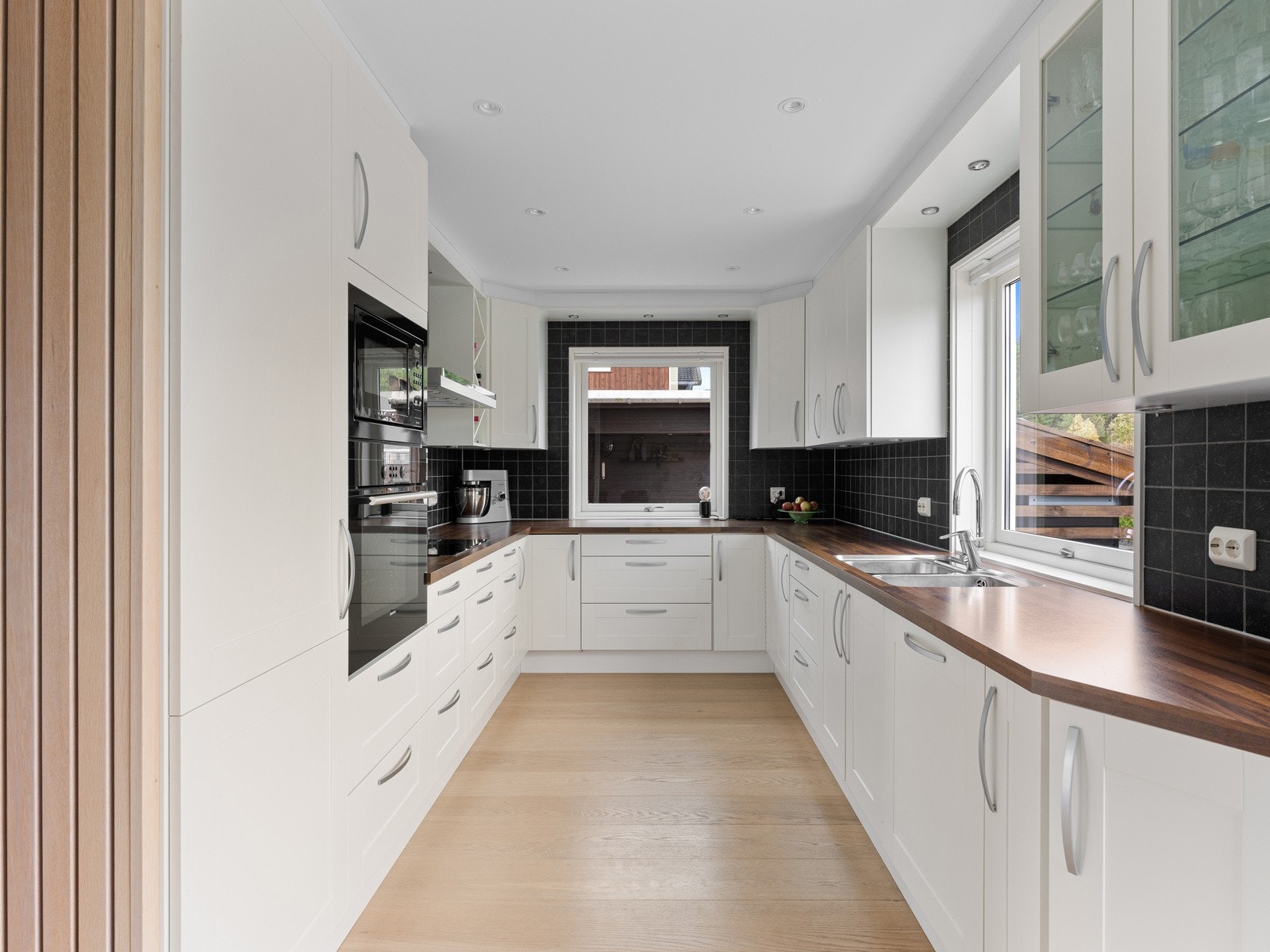 Kjøkkenet er trukket litt tilbake i egen sone og er funksjonelt utformet med god arbeidsflyt og rikelig skap- og benkeplass. Galleribilde