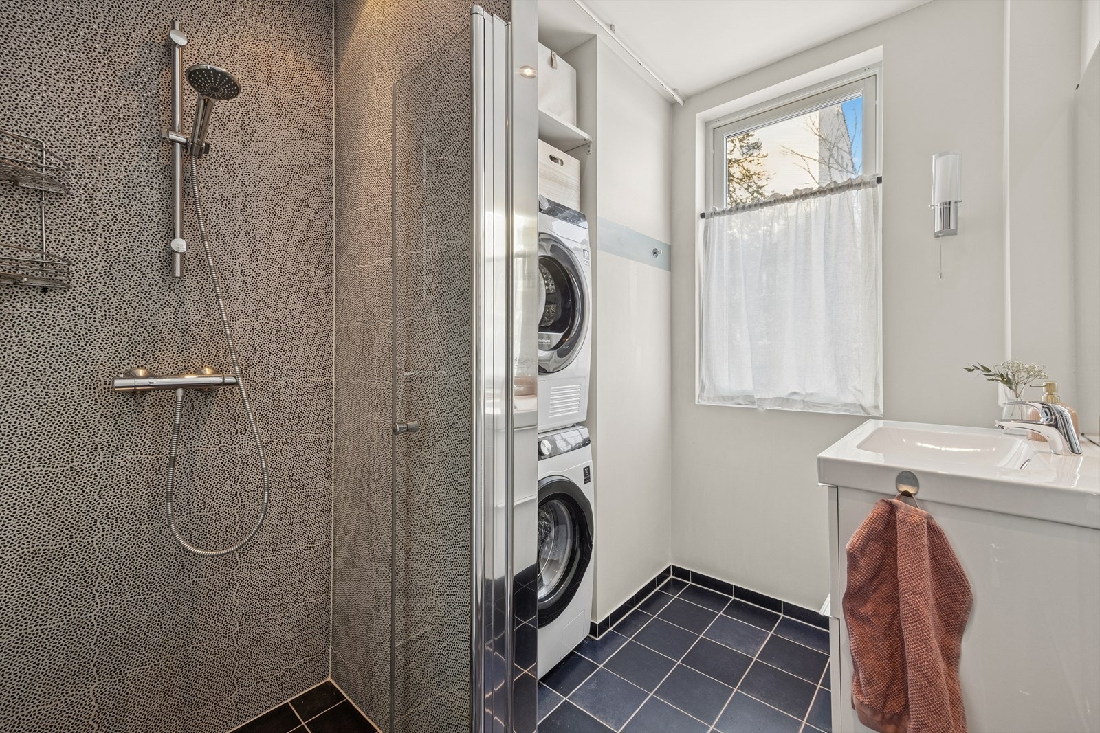 Her er det romslig dusj og god plass til vaskemaskin og tørketrommel. Naturlig lys inn på badet. Galleribilde