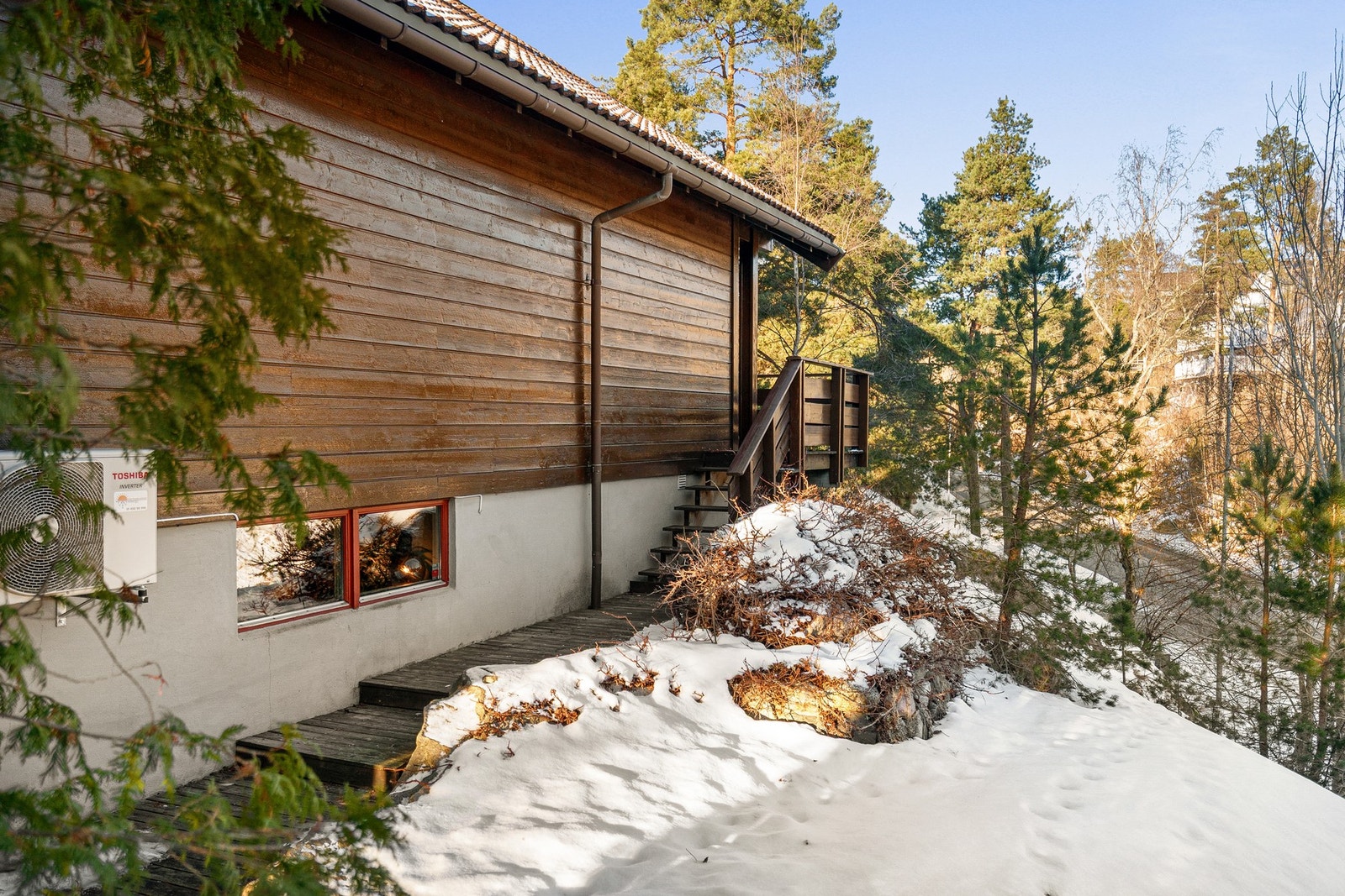 Tomtens terreng er kupert og er fint opparbeidet med diverse beplantning. Galleribilde