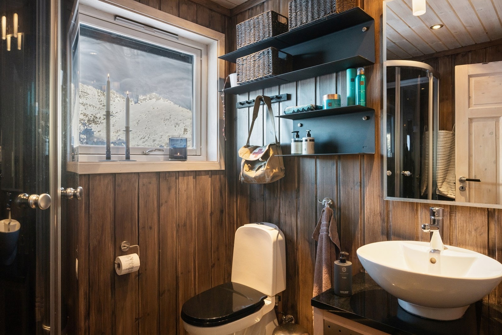 Badet har formskjært skifer med varmekabler, dusjkabinett og servantskap med steinplate. Galleribilde