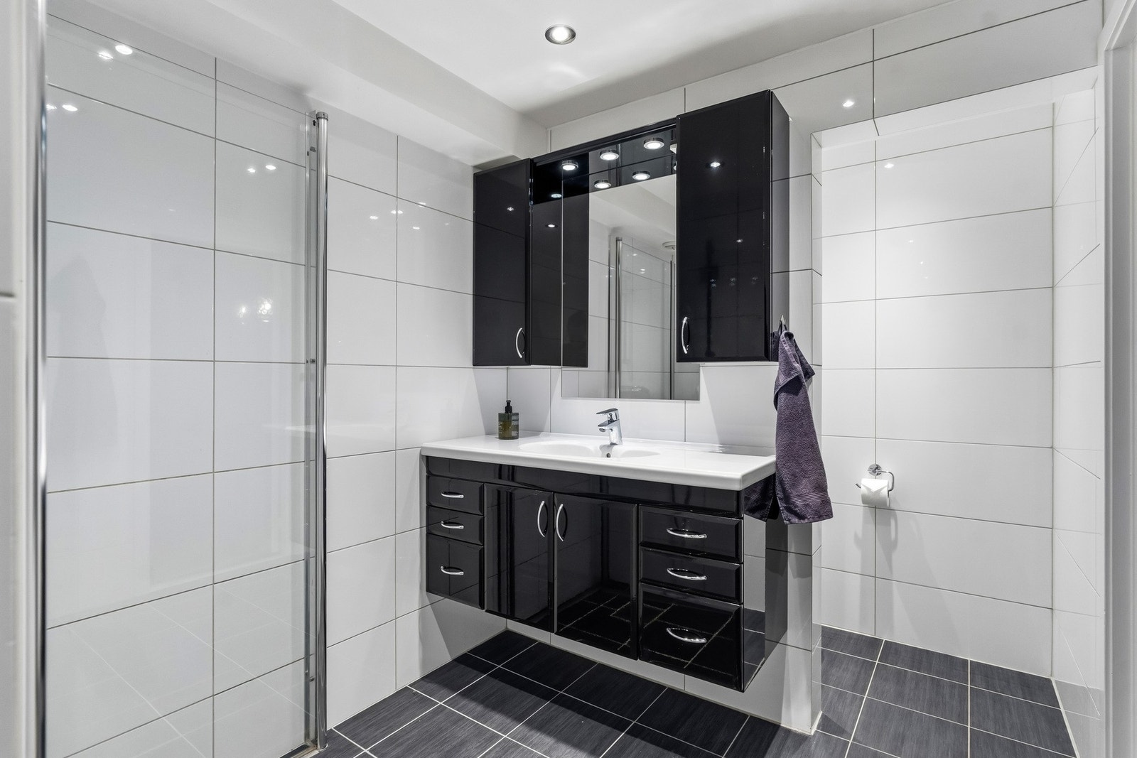 Glansfull innredning med god plass til oppbevaring av toalettsaker Galleribilde