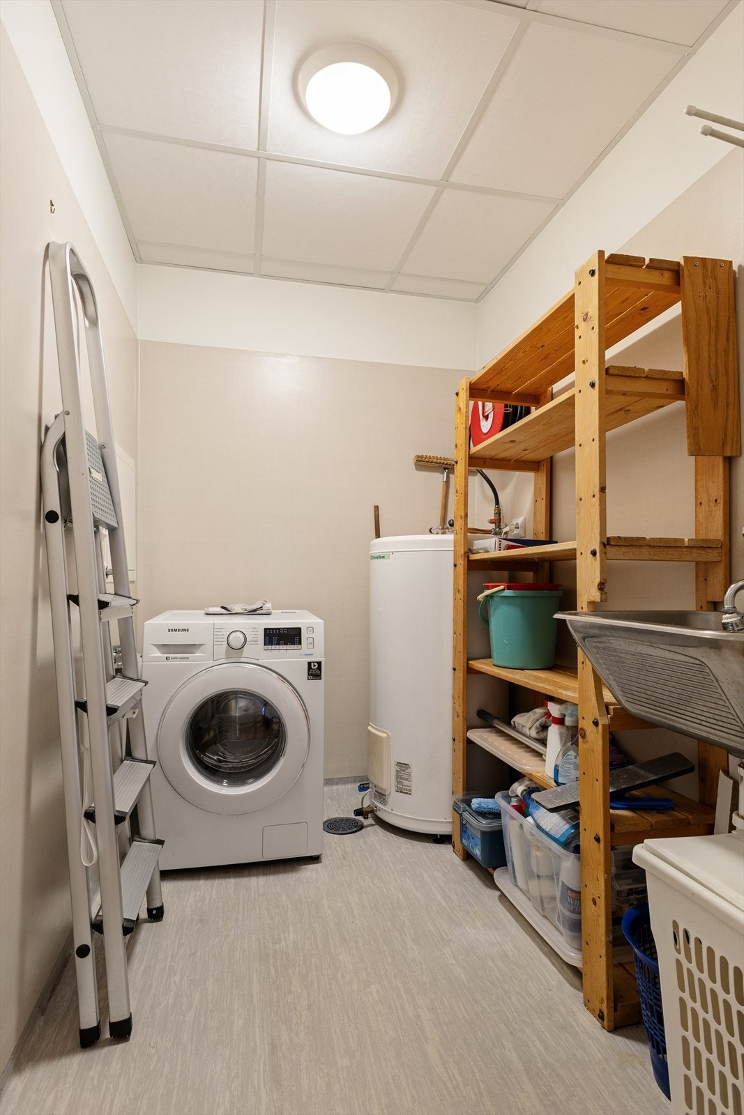 Like ved baderommet finner man et kombinert vaskerom og bod. Rommet er innredet med belegg på gulv og plater på vegg. Her har man ellers opplegg for vaskemaskin, varmtvannsbereder, utslagsvask og god lagringsplass. Galleribilde
