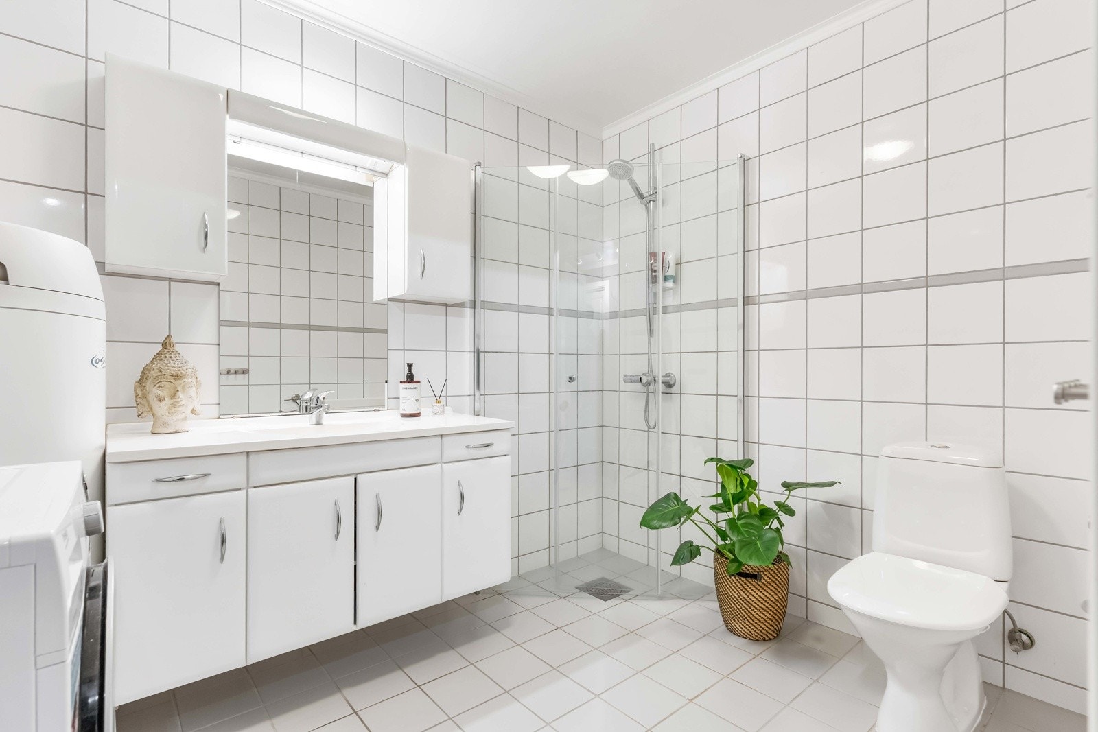 Bad med hvite fliser på gulv og vegger som gir et rent og tidløst uttrykk. Det er varmekabler i gulvet. Galleribilde