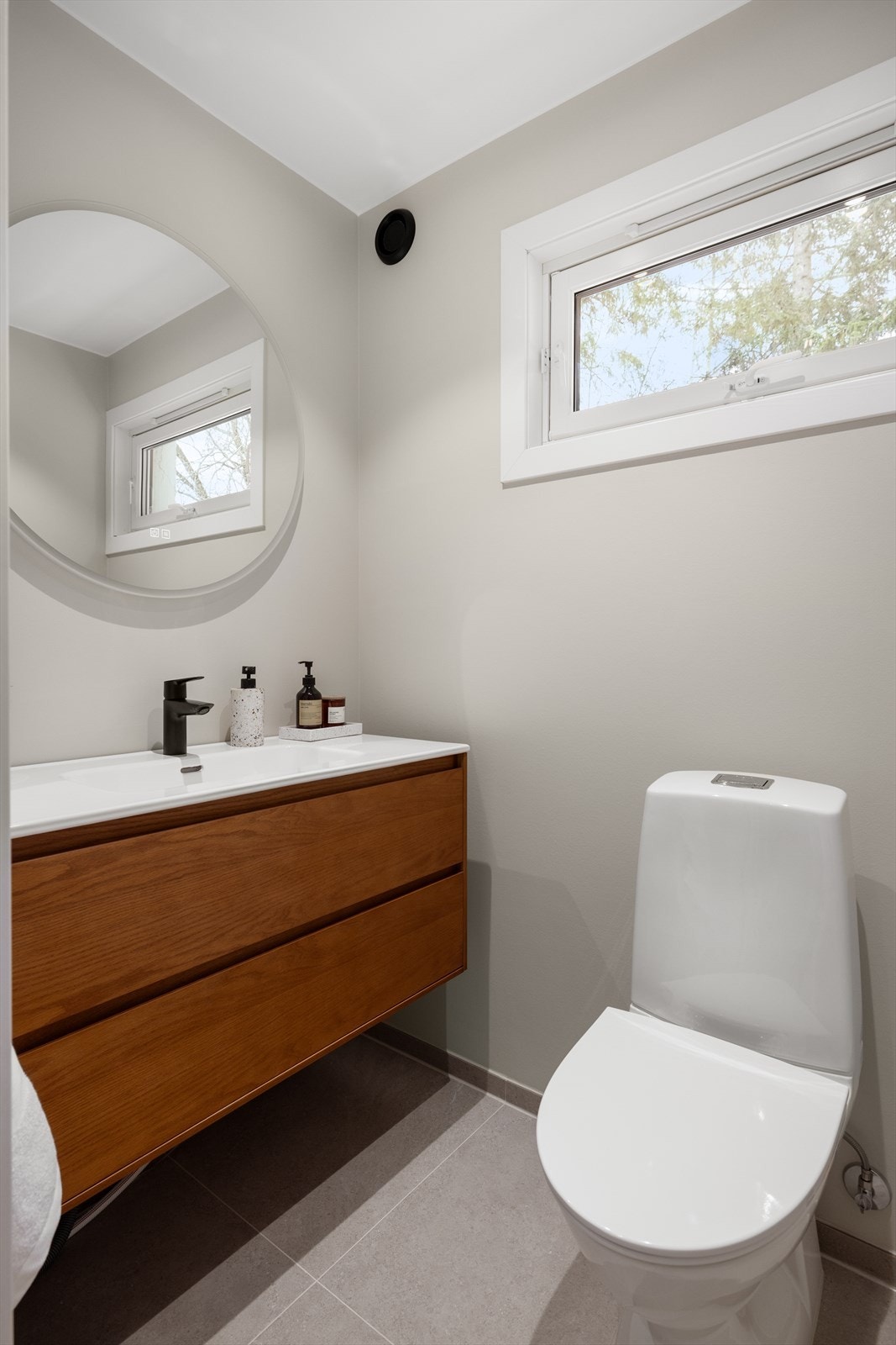 Separat toalett med pen servantinnredning og varmekabler i gulv. Galleribilde