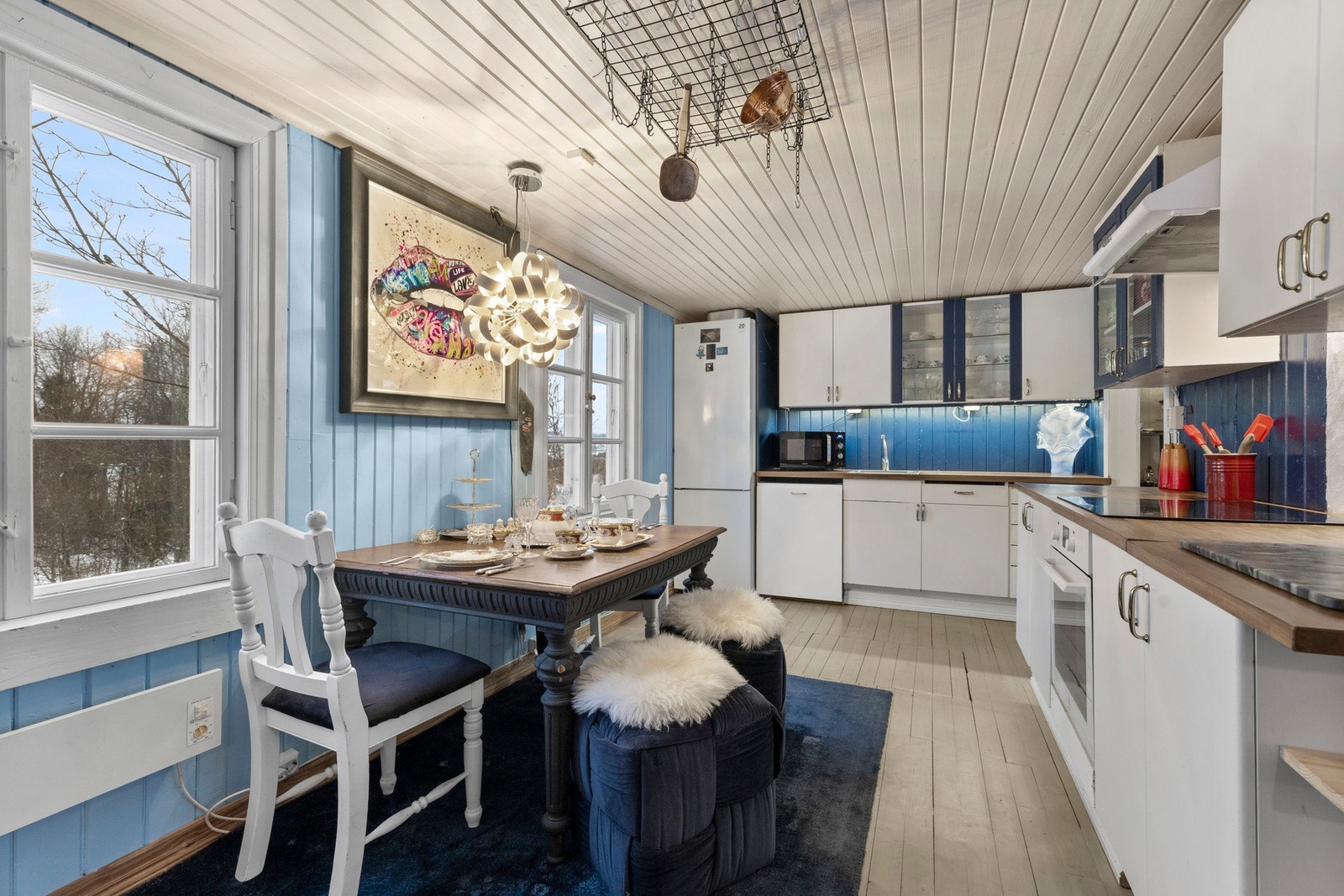 Kjøkkenet har innredning bestående av glatte fronter og benkeplater i laminat og heltre Galleribilde