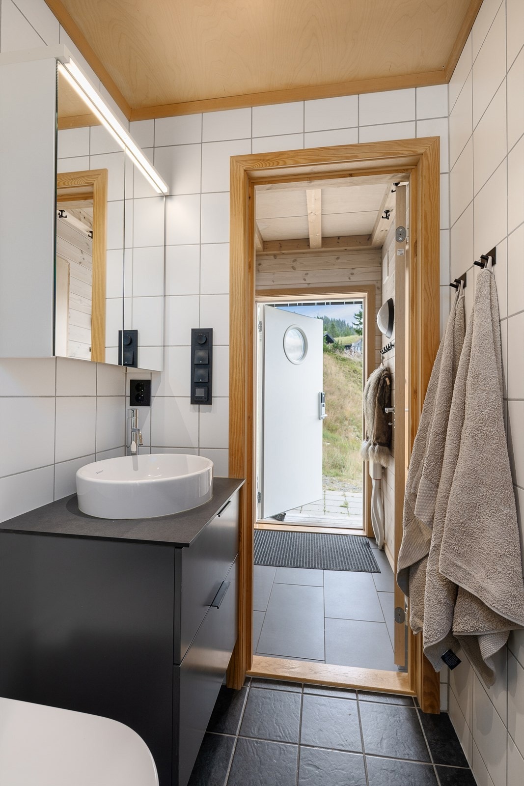 Badet har servant med underskap og speil med belysning. Galleribilde