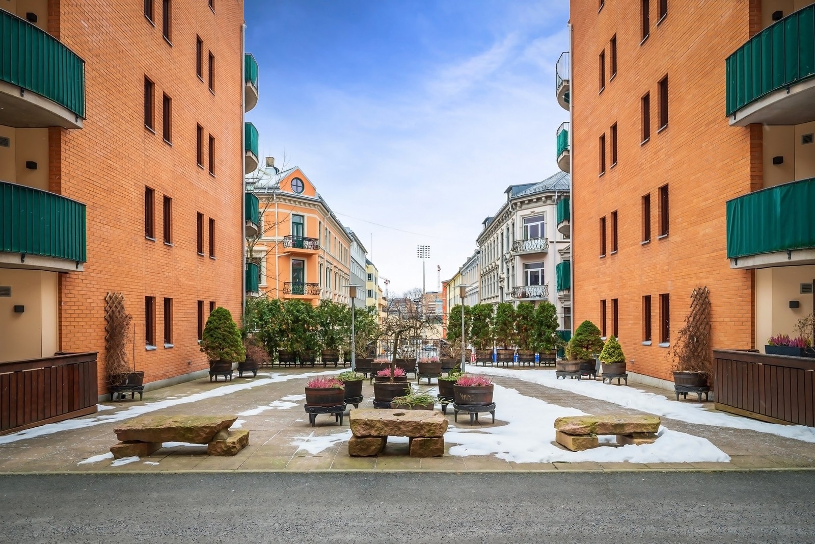 Pent opparbeidet uteområde som er hellelagt og har flott beplantning, sittebenker og prydbusker Galleribilde