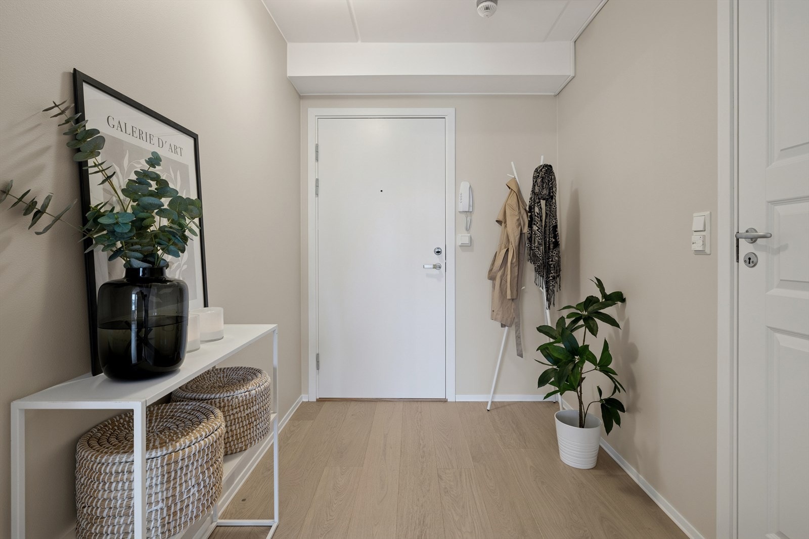 Du ønskes velkommen inn i en lys og pen entré med god plass til både yttertøy og sko. Det er også mulighet for å etablere en praktisk garderobeløsning her. Dørtelefon er montert på veggen for enkel mottak av besøkende. Galleribilde