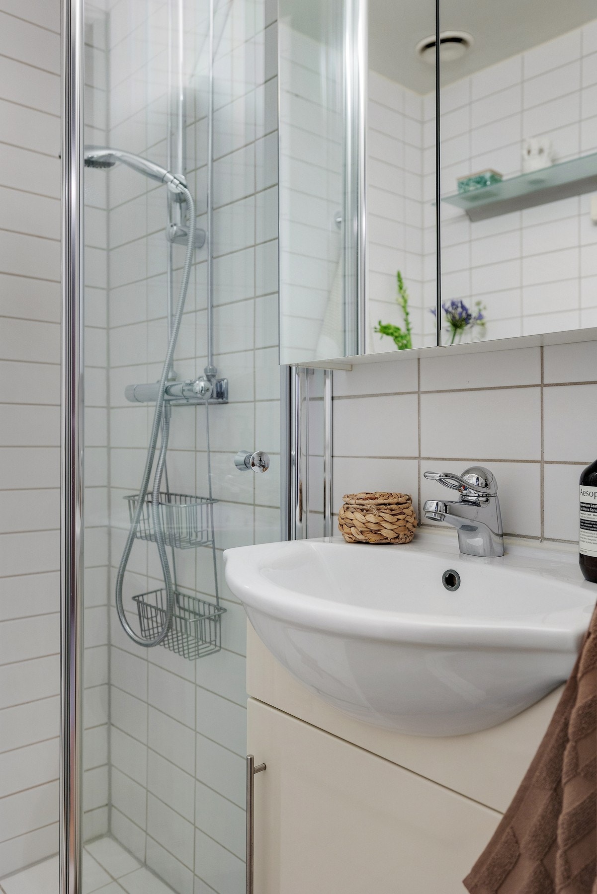 Baderomsinnredning bestående av benkeskap og veggskap med speil og glatte fronter. Galleribilde