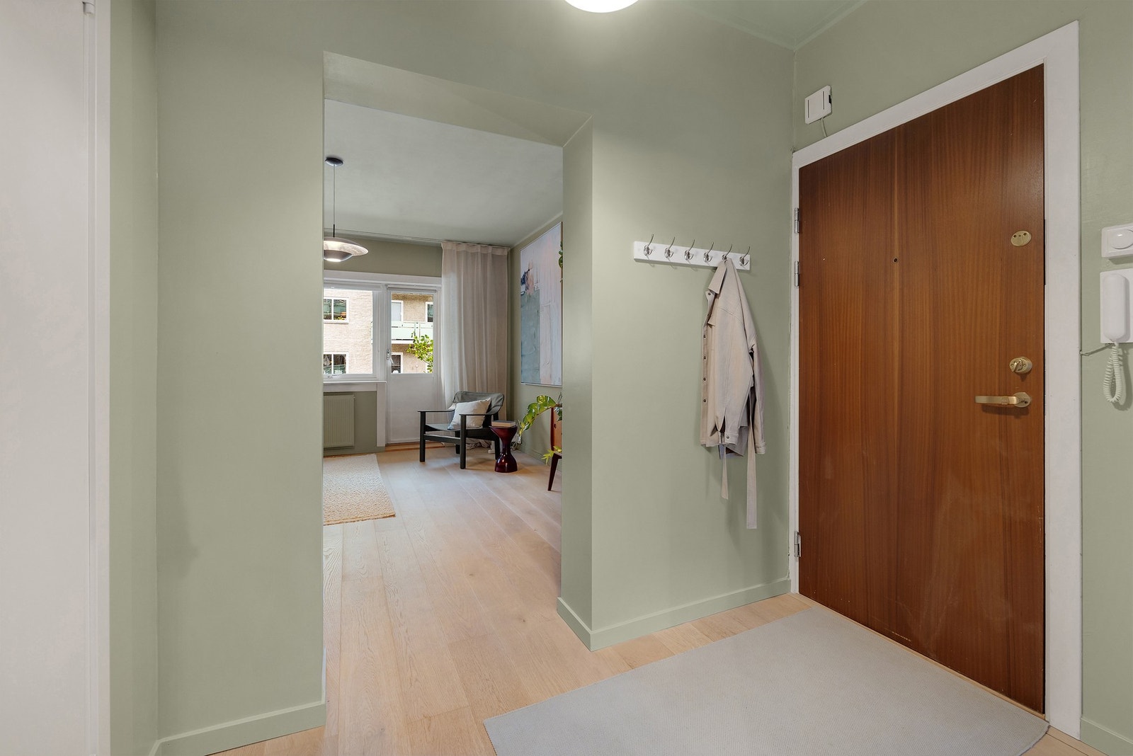 Lys og innbydende entré med vegger og tak malt i samme, rolige fargetone som gir et moderne og helhetlig uttrykk. Galleribilde