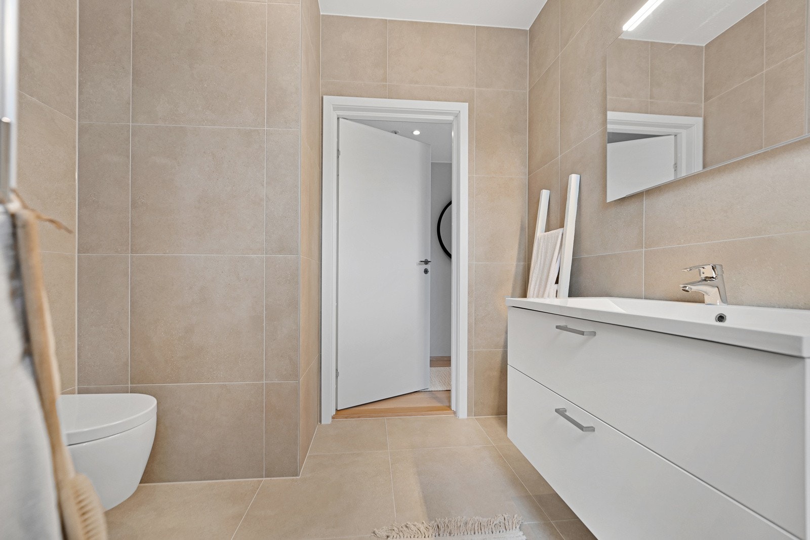 Veggheng toalett med soft close-sete, stilren servant og god belysning. Et funksjonelt og estetisk rom. Galleribilde