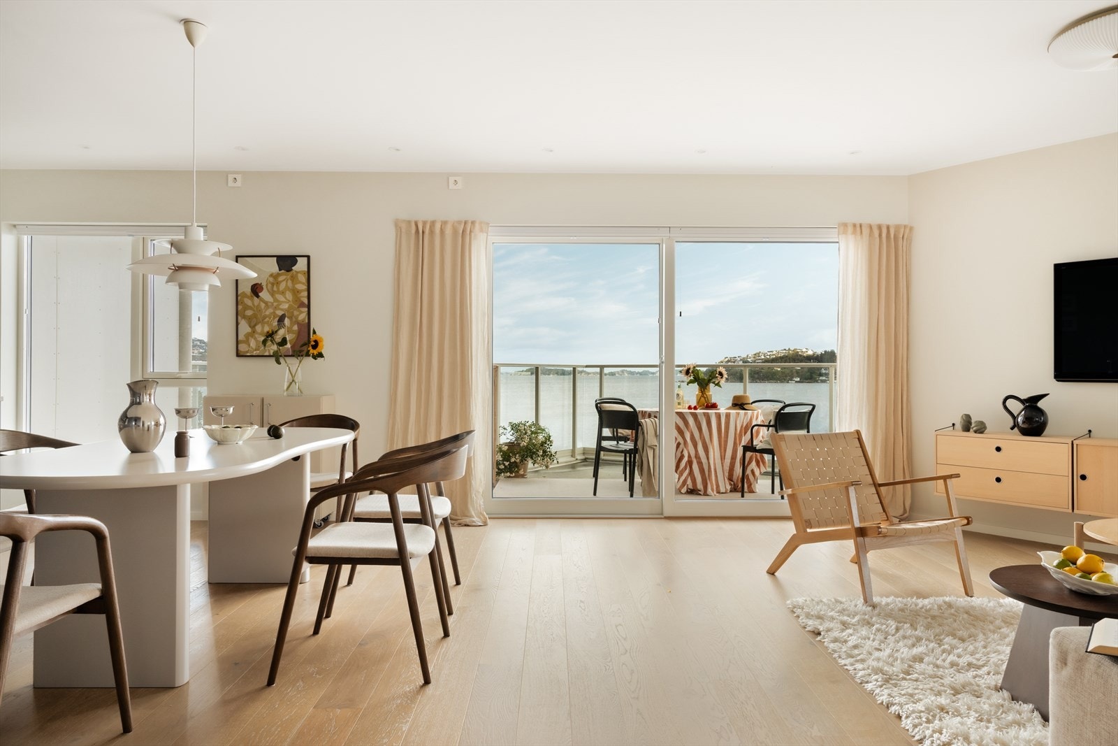 Stue og kjøkken rammes inn av store vindusflater, utsikt, lys og kveldssol. Lune farger og gode kvaliteter i hele leiligheten. Galleribilde