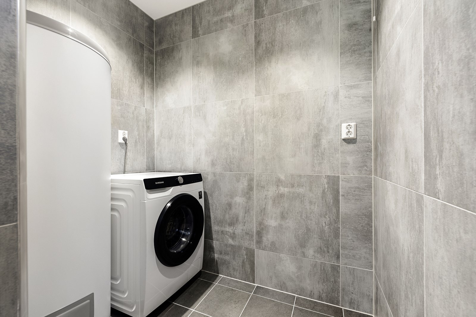 Delen som tidligere utgjorde opprinnelig matbod er i dag innredet med vaskemaskin og varmtvannsbereder på 200 liter. Galleribilde