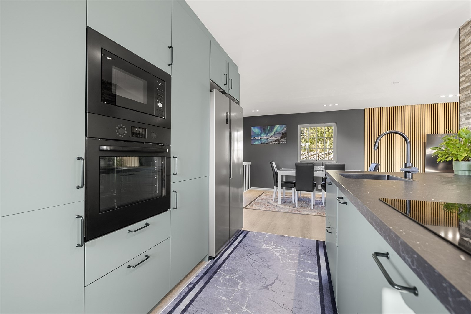 Her får du en moderne, tidsriktig og praktisk kjøkken med en svær kjøkkenøy. Galleribilde