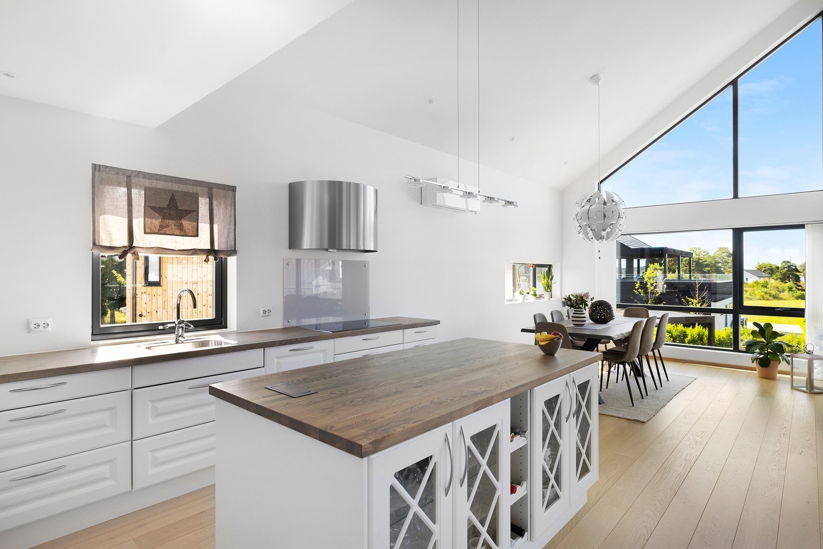 Med lyse flater, stilrene detaljer og åpen løsning mot stuen, får kjøkkenet en luftig romfølelse som forsterkes av de store vindusflatene Galleribilde