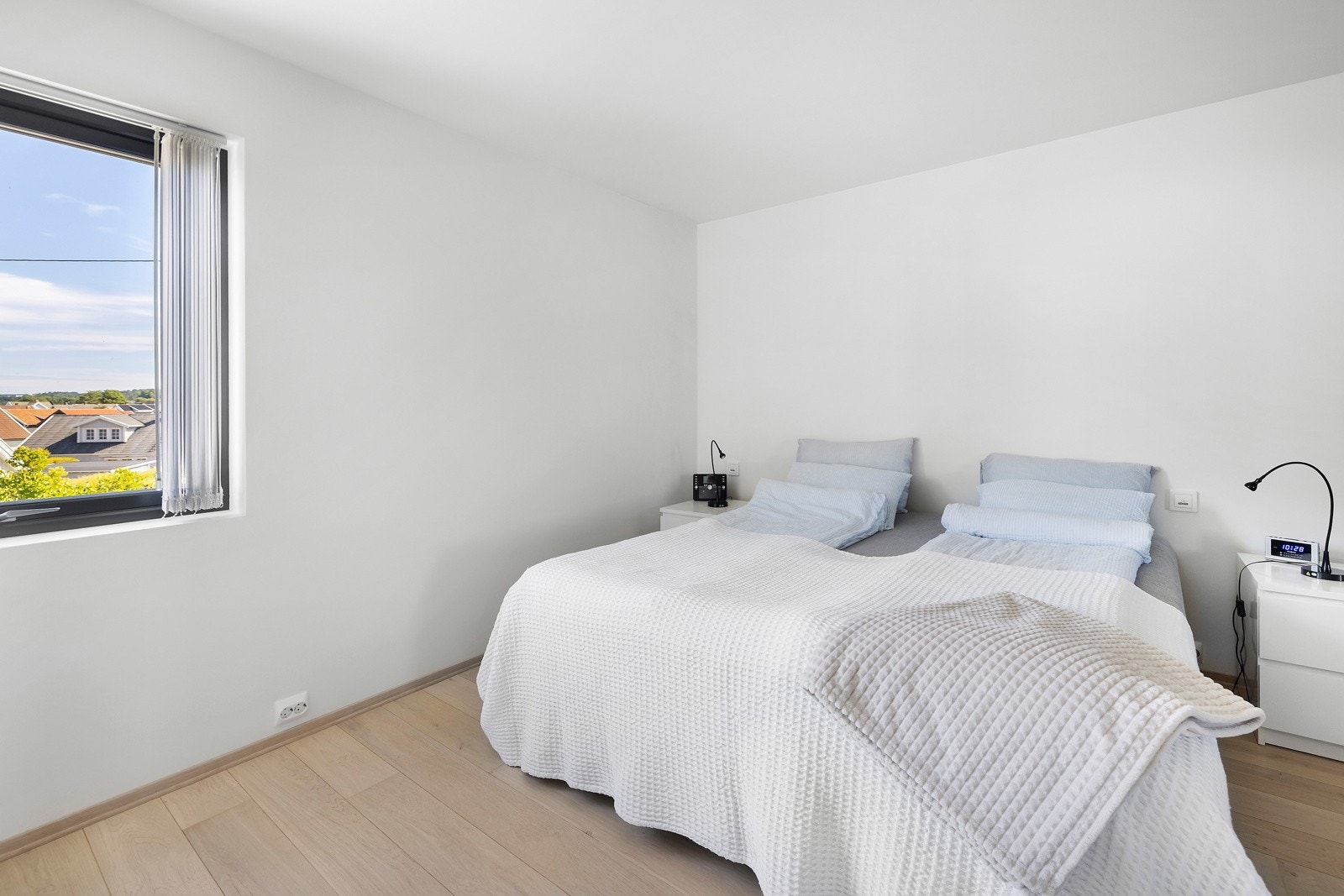 Her får du et soverom med lyse flater og moderne stilvalg som gjenspeiler eneboligens gjennomførte og nymoderne stil Galleribilde