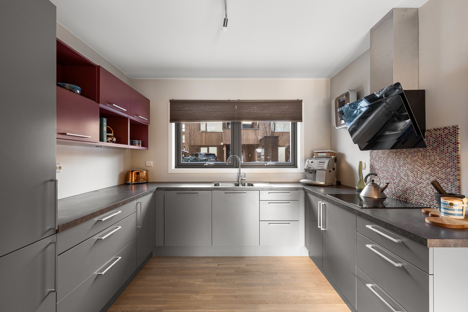 Kjøkkenet har glatte fronter i en stilren gråtone. Galleribilde