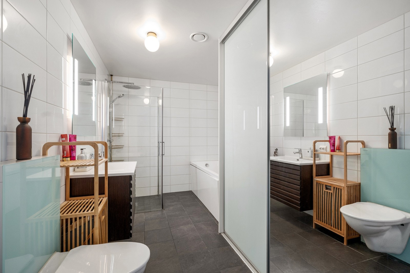 Her finner du badekar - perfekt for avslapning etter en lang dag - samt vegghengt toalett med glassbox sisterne, servant, skyvedørsgarderobe med opplegg for vaskemaskin og nedsenket dusjsone. Galleribilde