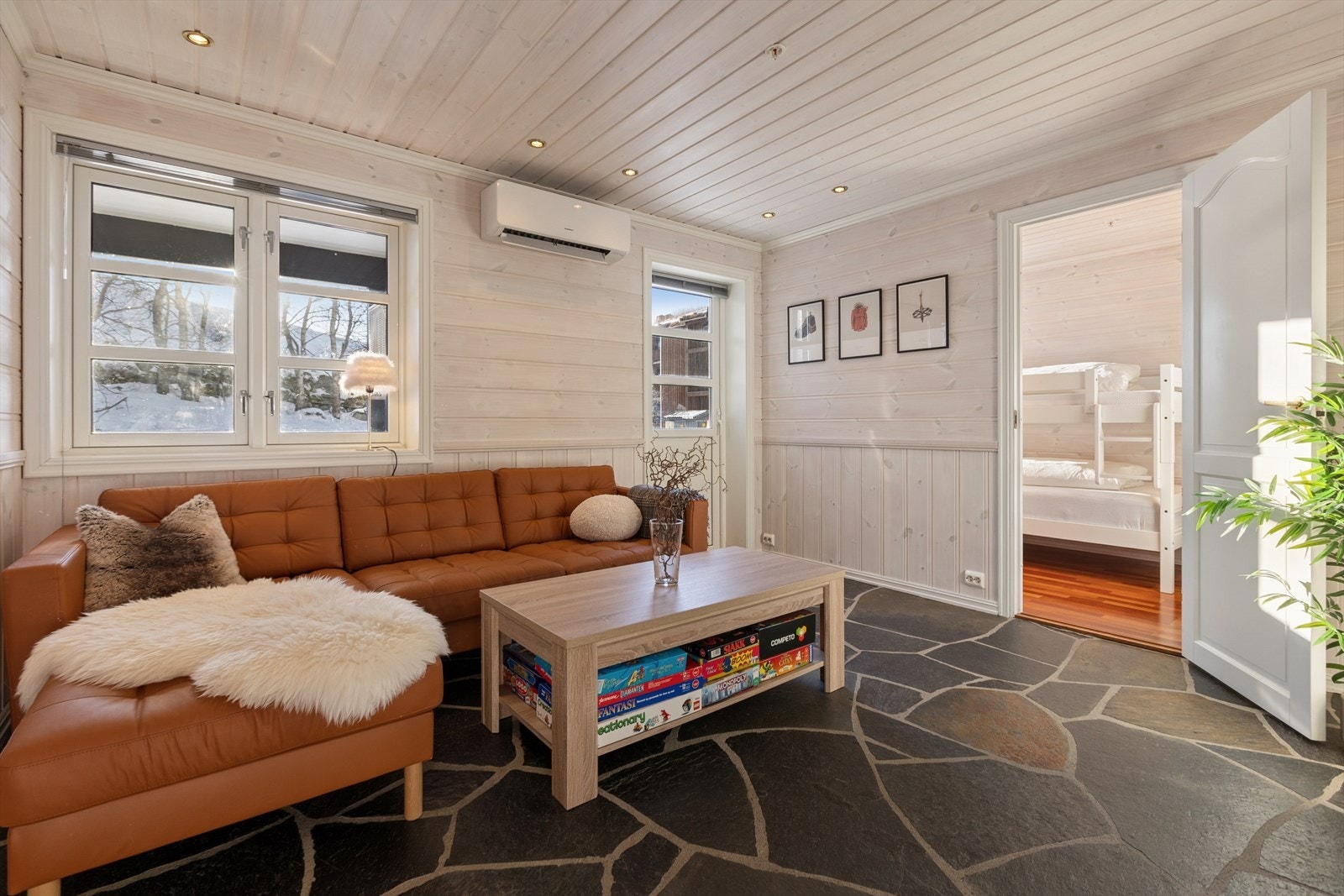 Stuen i underetasjen er utstyrt med varmepumpe som sørger for jevn og energieffektiv varme. Herfra har man også utgang til den andre uteplassen på bakkeplan. Galleribilde