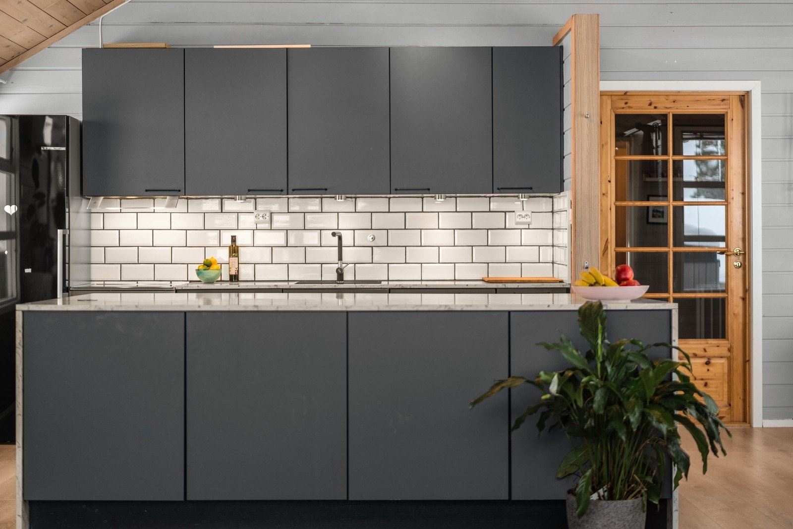 Stilrent og moderne kjøkken med flis over benk. Galleribilde