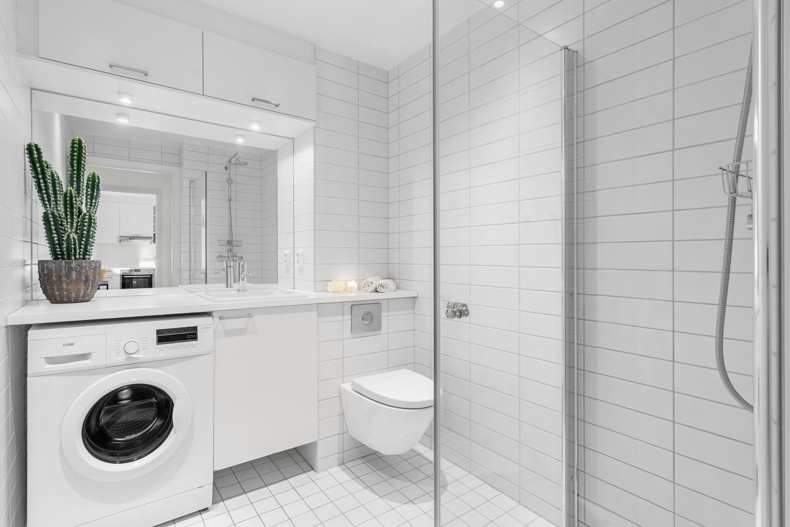 Romslig, flislagt baderom av typen prefabrikkert våtromskabin med hovedkonstruksjoner fra byggeårene. Galleribilde