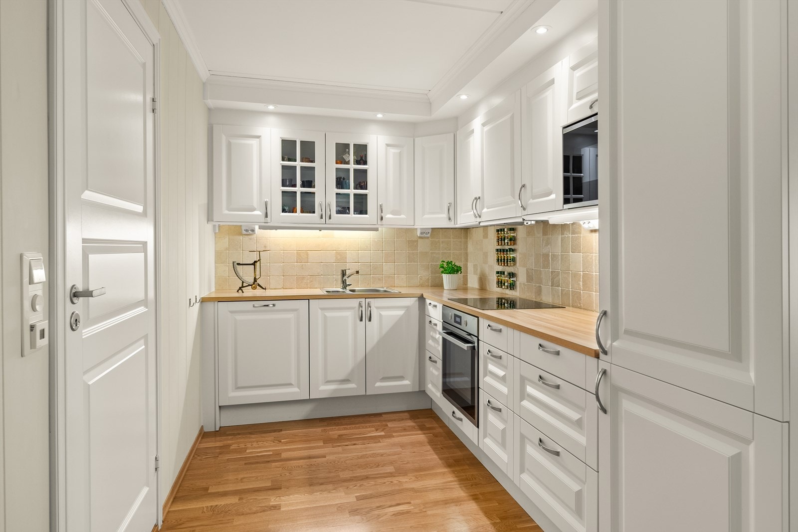 Kjøkkenet har lyse fliser over benkeplaten. Galleribilde