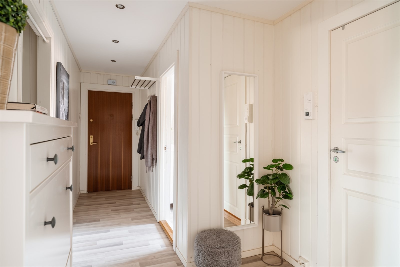En lys entré med laminatgulv og malte vegger ønsker velkommen inn. Galleribilde