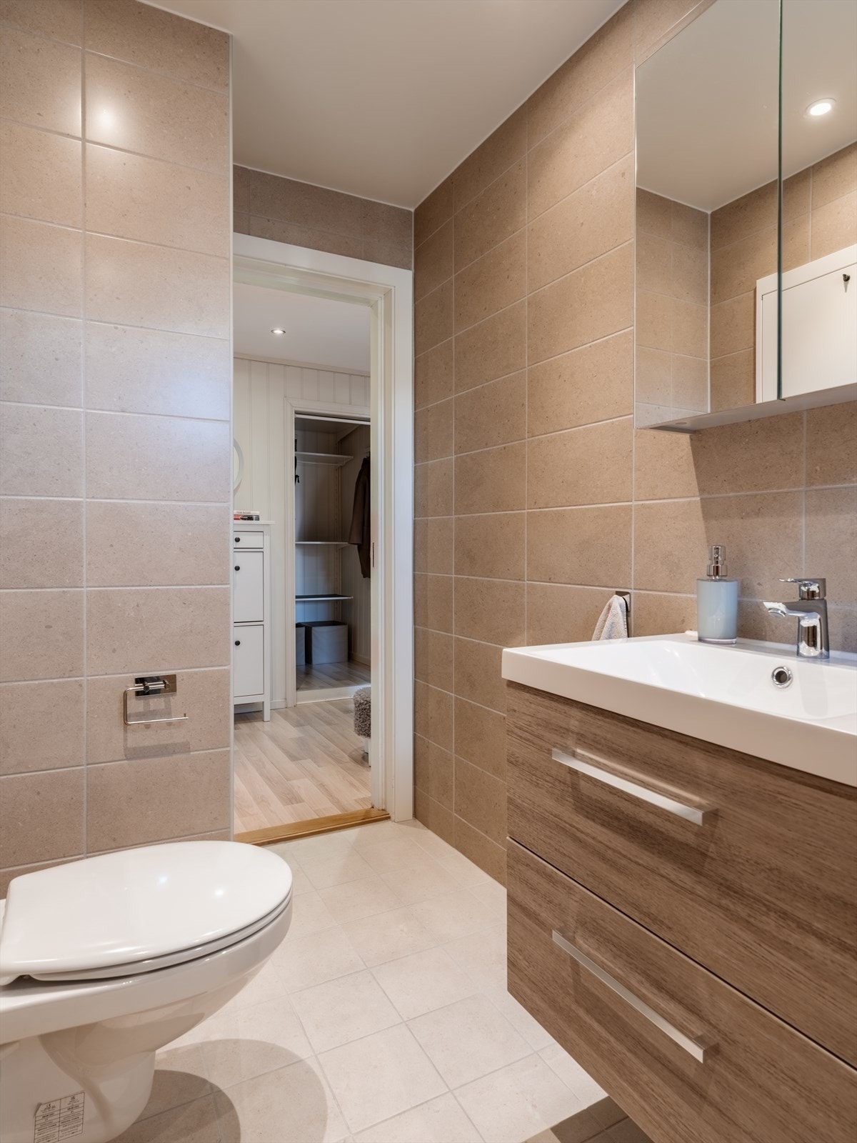 Innredningen inkluderer servant med underskap og vegghengt toalett. Galleribilde