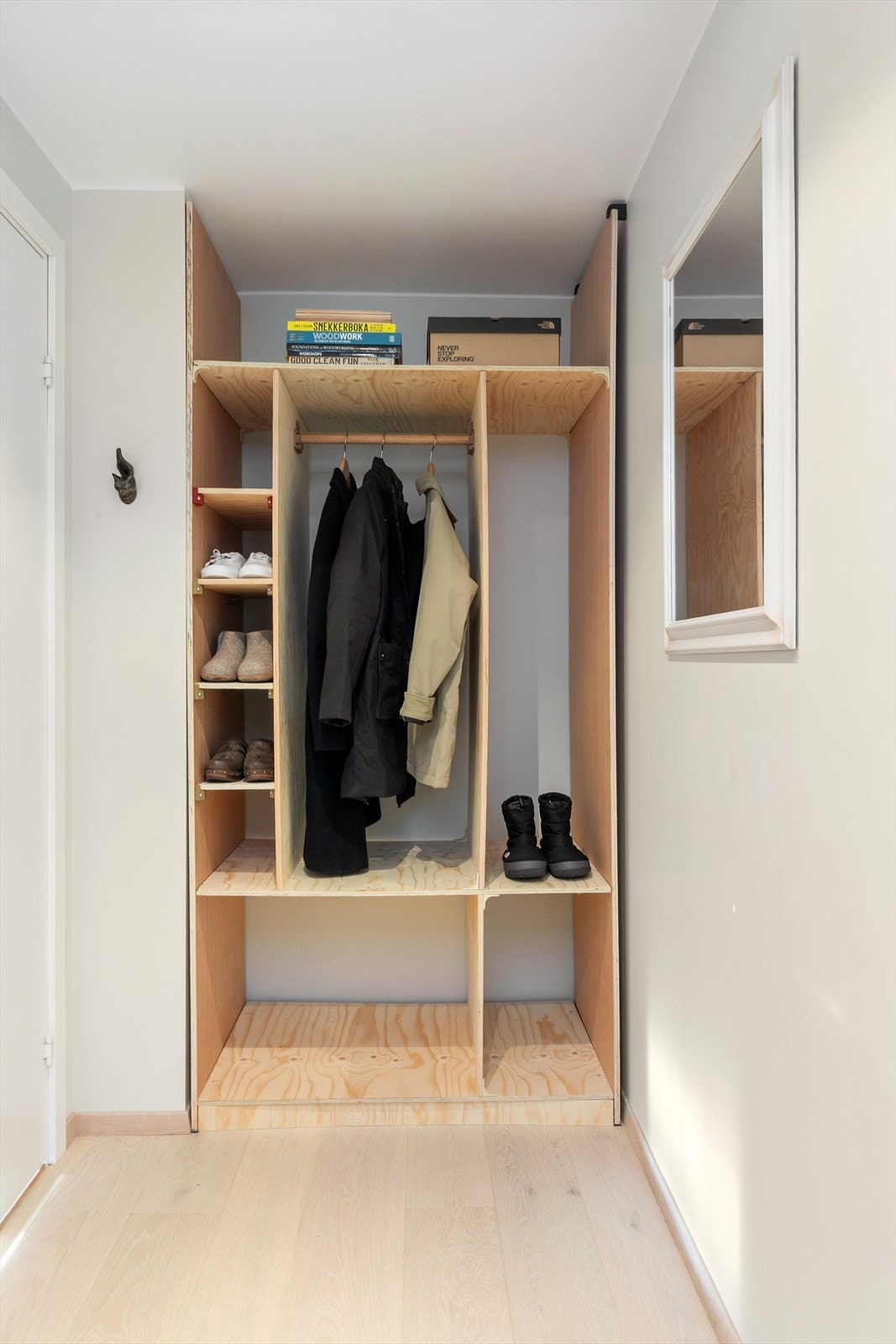 Bak døren til kjøkkenet er det plassbygget stilig garderobeløsning i kryssfinér Galleribilde
