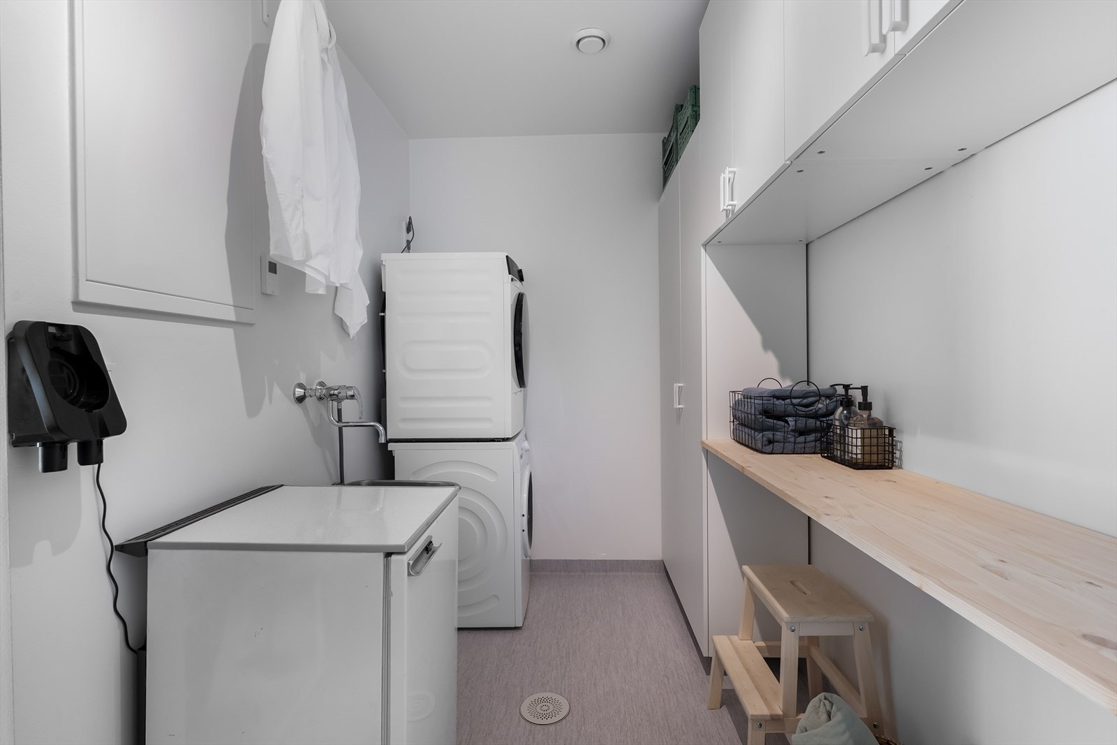 Rommet er utstyrt med utslagskum i stål, opplegg for vaskemaskin og praktiske skapreoler. Her finner du også boligens varmtvannsbereder og vannfordelerskap for gulvvarmen Galleribilde