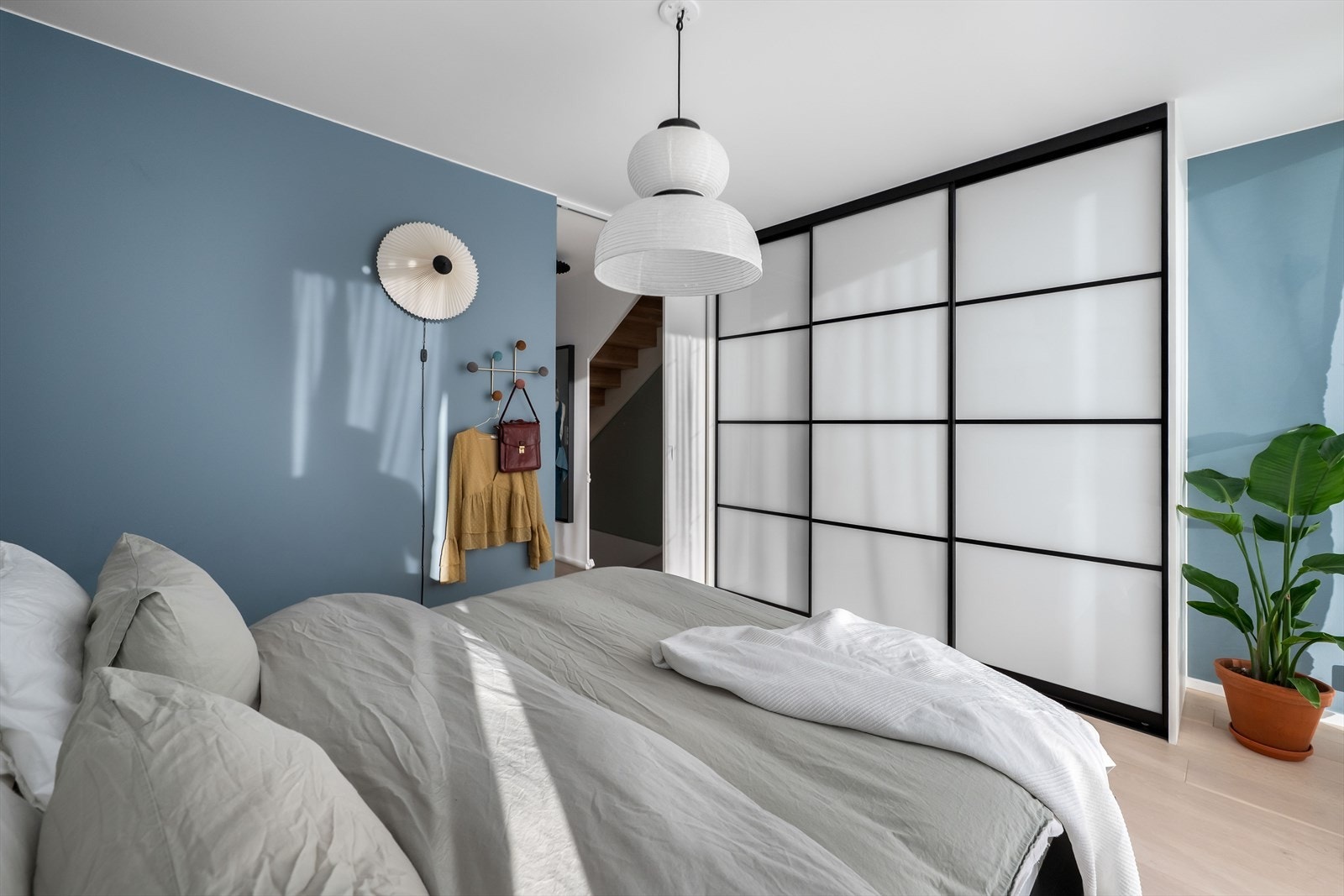 Hovedsoverommet har praktisk skyvedørsgarderobe med glatte fronter og sorte detaljer Galleribilde