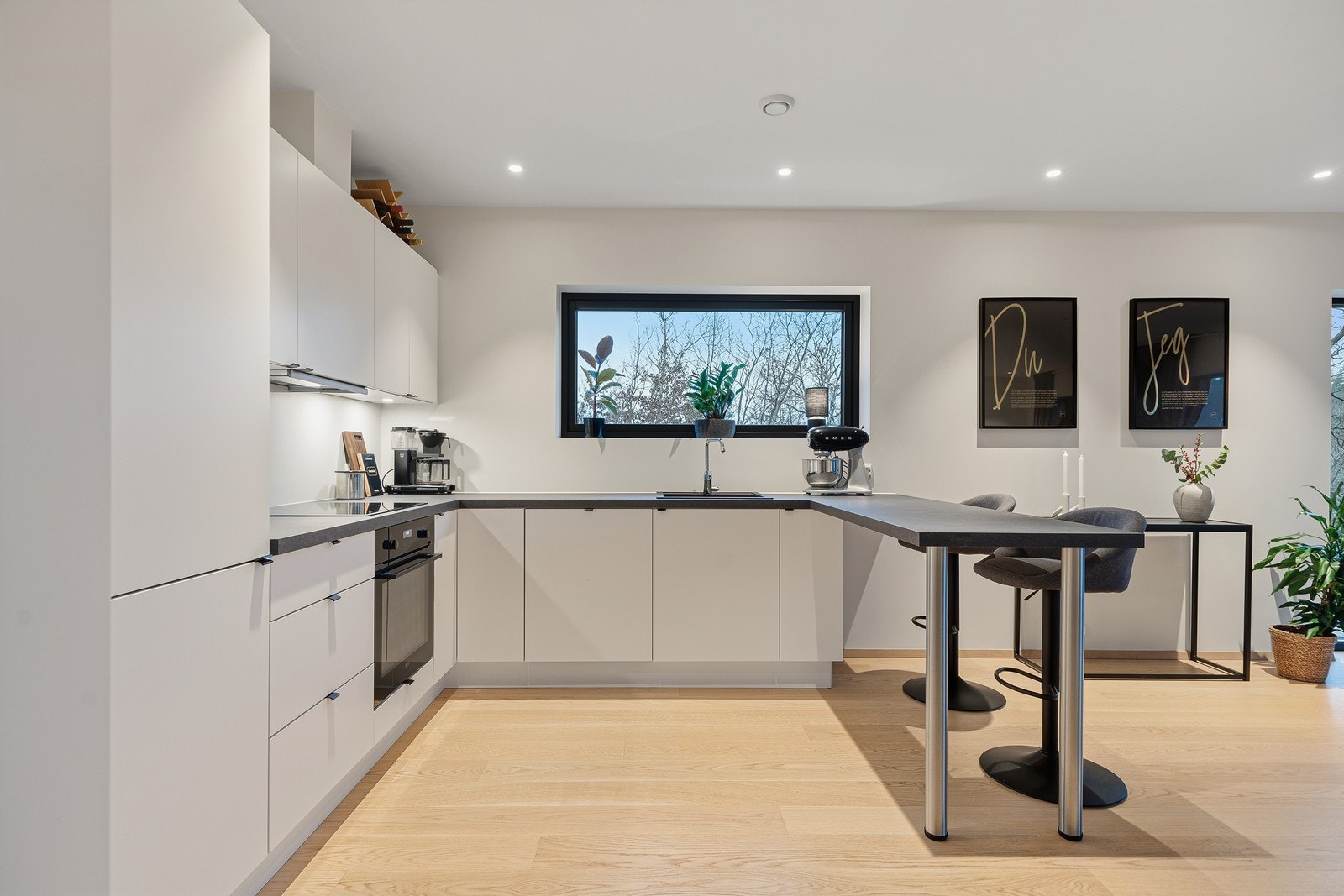 Kjøkkenet består av integrerte hvitevarer, vask og platetopp Galleribilde