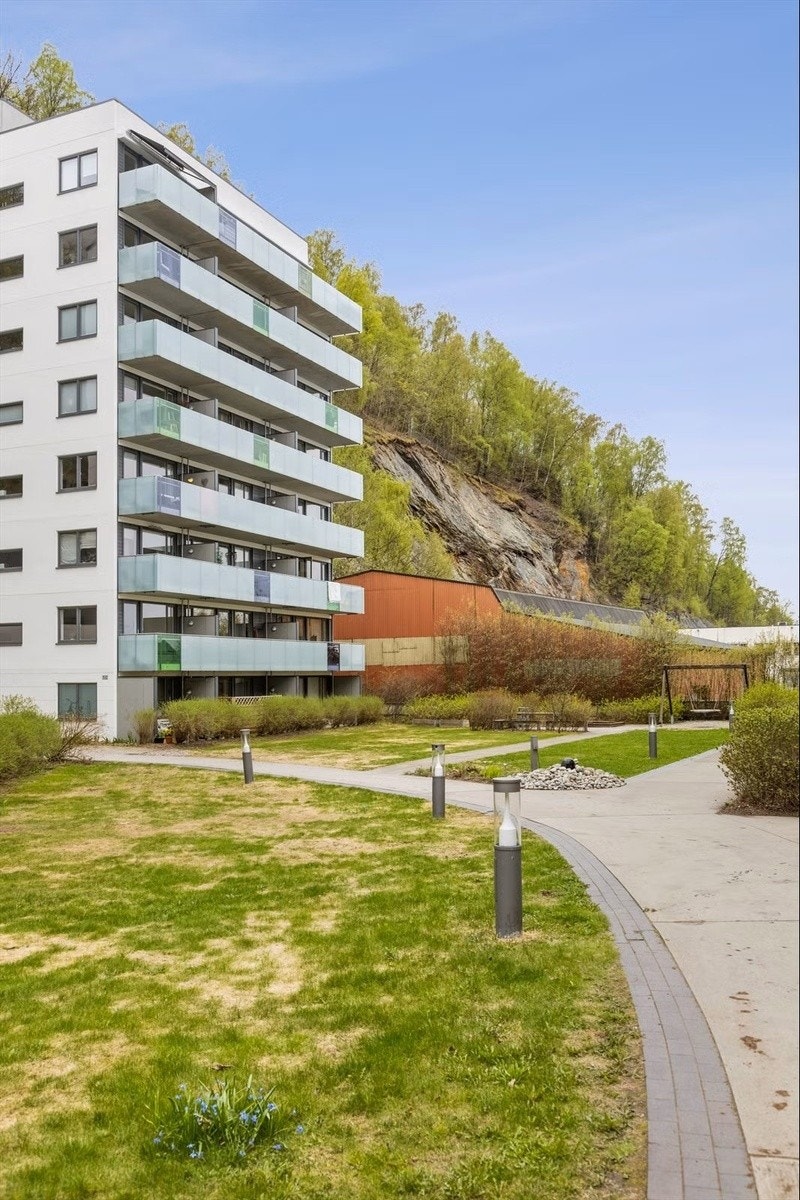 Pent opparbeidet felleareal på ca. 415 m² med asfalterte internveier, gressplen, lekestativ og utelys. Galleribilde