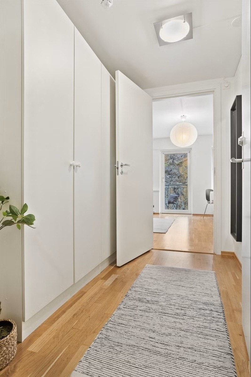 Her blir du møtt av en luftig og innbydende entré med lyse fargevalg på veggen og 3-stavs eikeparkett på gulv, som forøvrig er gjennomgående for leiligheten. Galleribilde