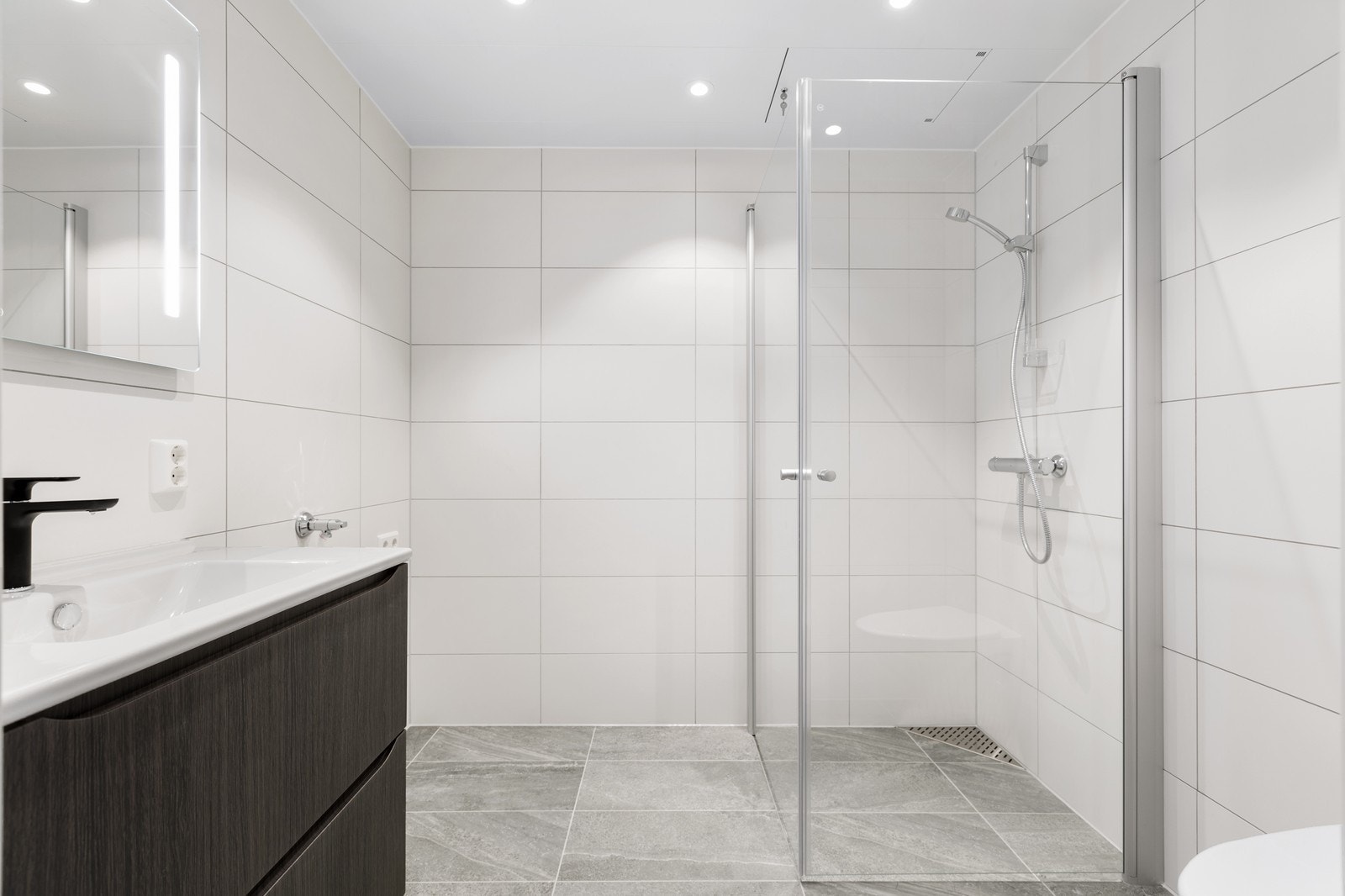 Flislagt bad med gulvvarme og opplegg for vaskemaskin. Galleribilde