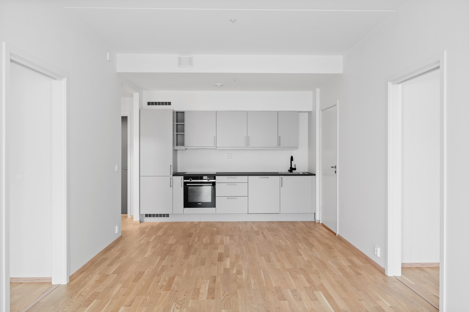 Grått kjøkken med integrerte hvitevarer. Galleribilde