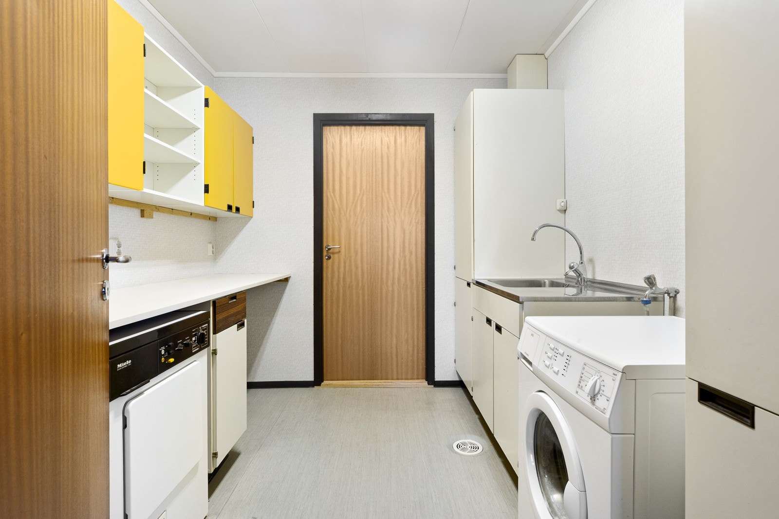 Vaskerom med opplegg for vaskemaskin og behov for oppgradering. Galleribilde